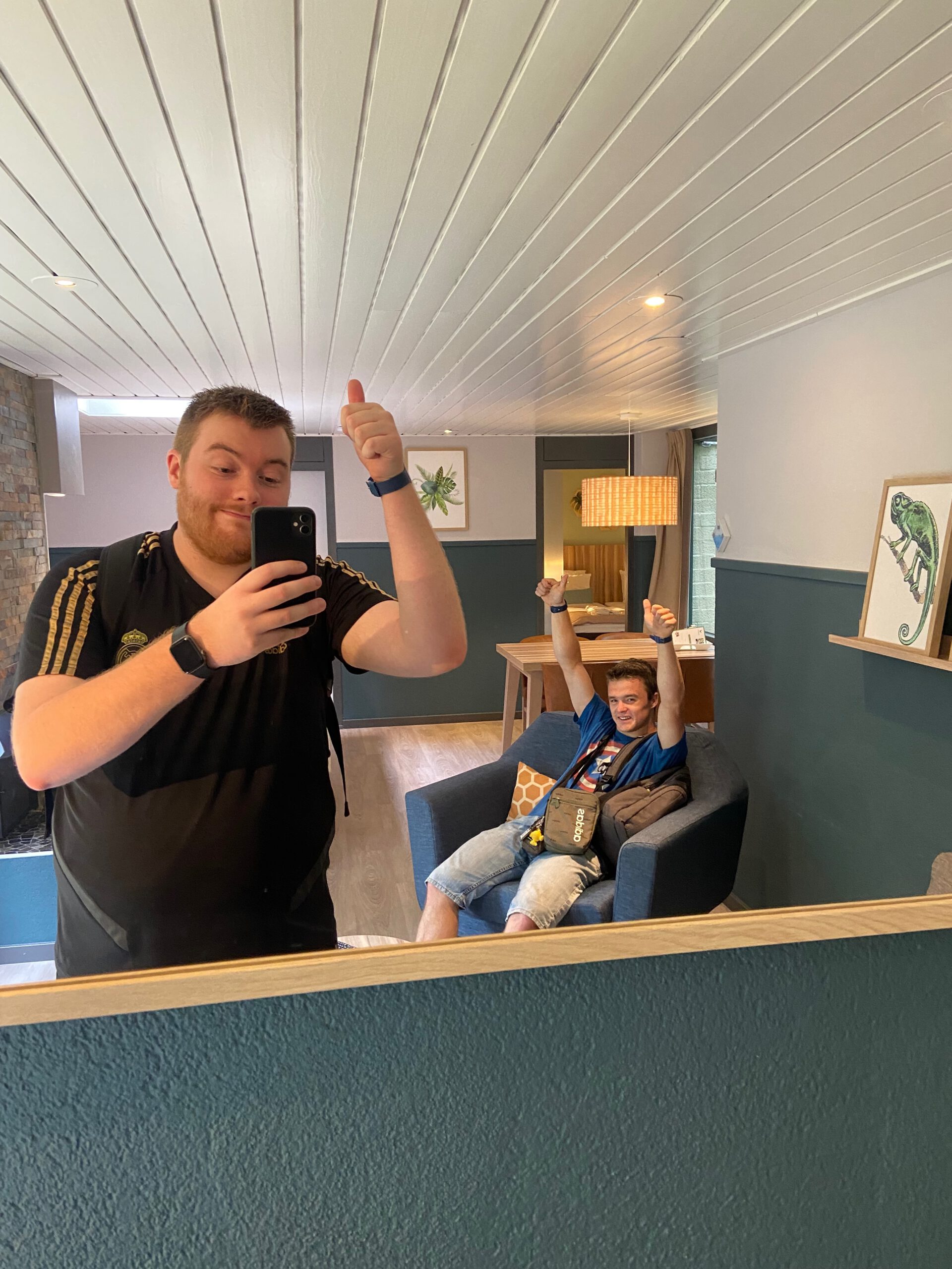 Timo van den Berg and Peter Smit celebrating inside Center Parcs Het Heijderbos VIP cottage 978, spacious renovated living room with modern interior, open fireplace and comfortable seating area.