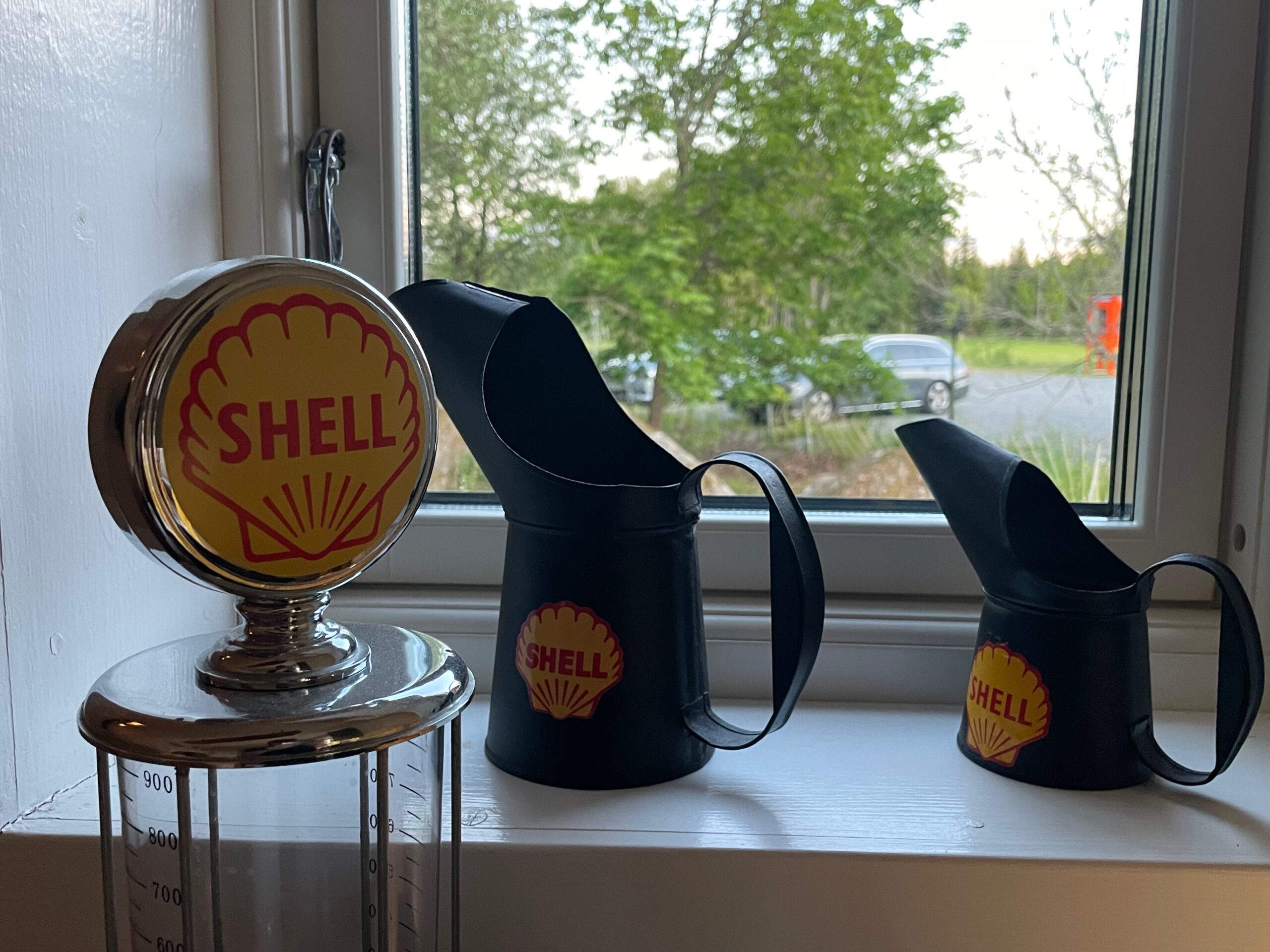 Shell Gas Station Airbnb Enkoping Sweden interior featuring vintage Shell logo decor, classic fuel measurement display and nostalgic coffee pitchers by the window