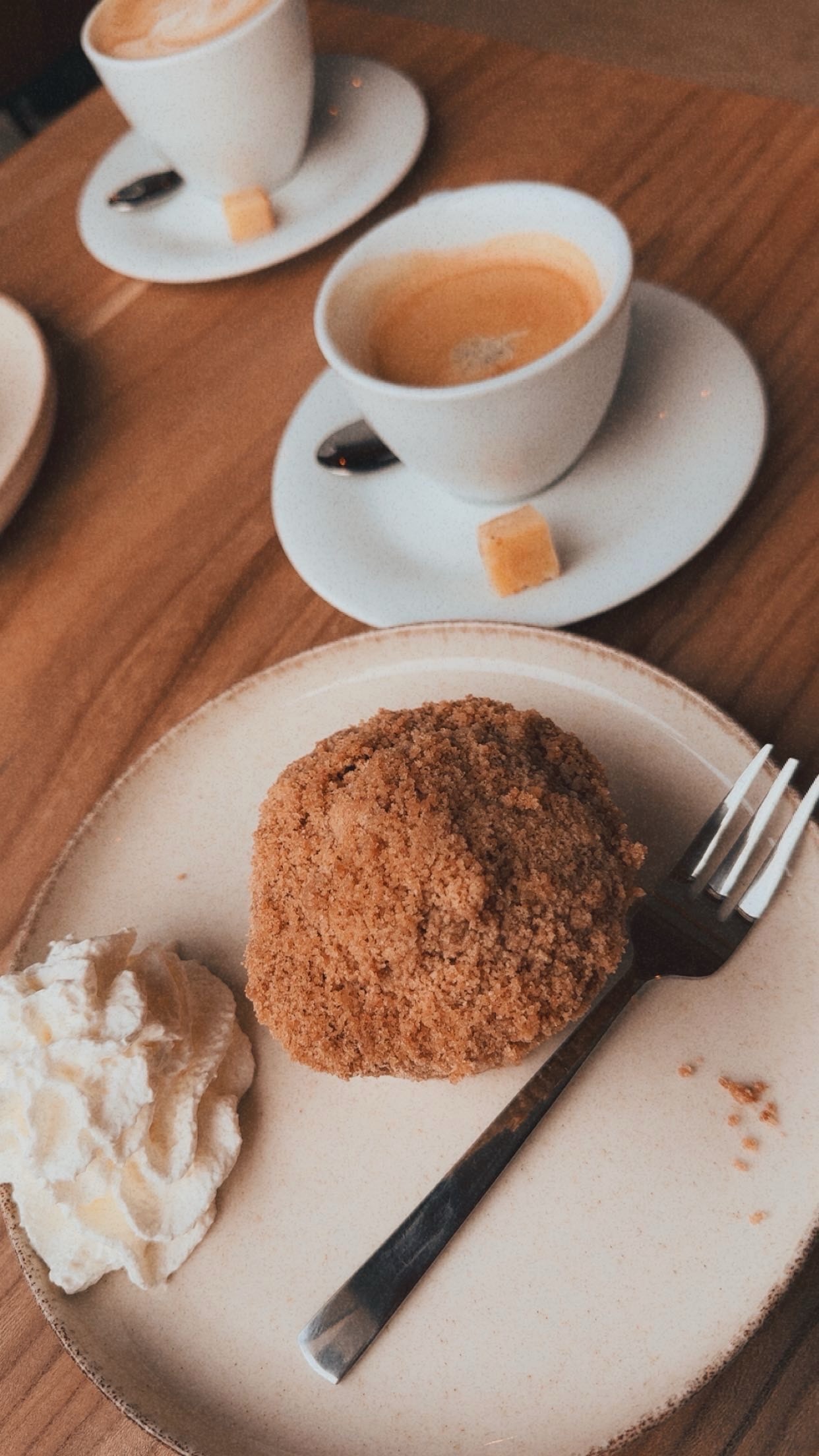 Fresh coffee and apple pastry served at BentGoud Bentwoud, showing cappuccino, espresso, whipped cream, and homemade cake on a wooden table