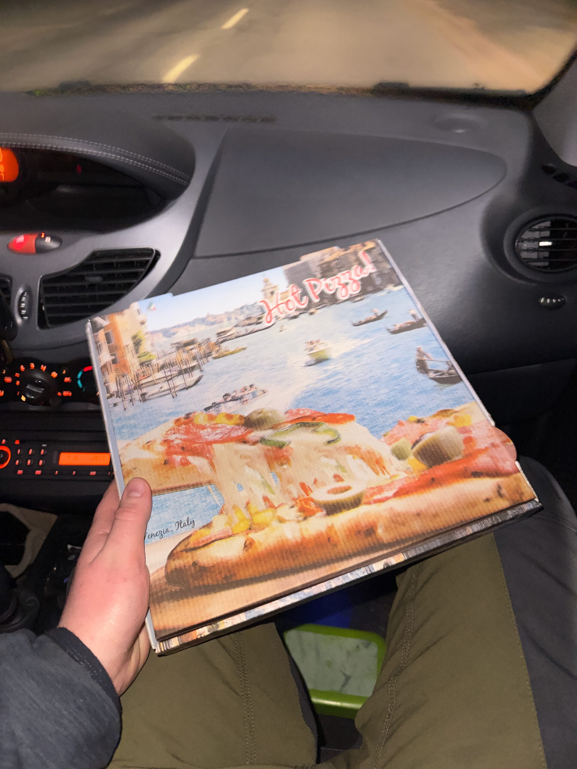 Pizzeria Il Genio Karken restaurant review showing a takeaway pizza box held inside a car at night, highlighting the popular takeout option after dining at Pizzeria Il Genio near the German Dutch border.