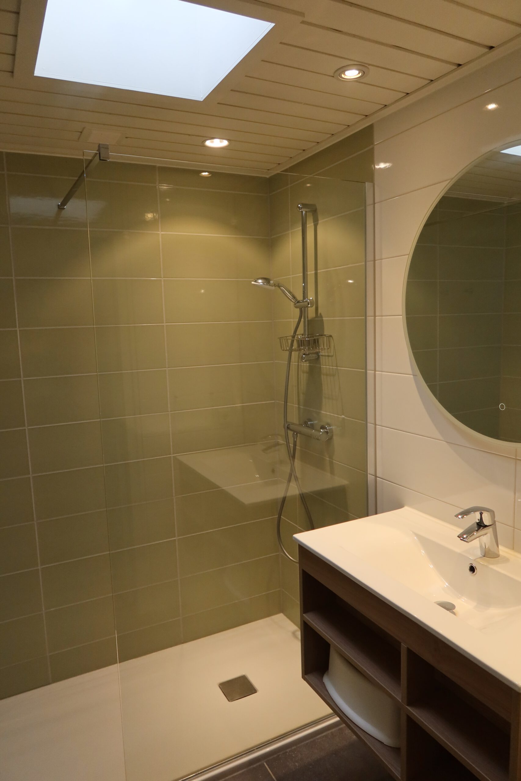 Walk in shower area of Center Parcs Het Heijderbos 4 pers. Premium HB1922 cottage 965 showing glass shower screen, rainfall shower system and tiled green wall finish.