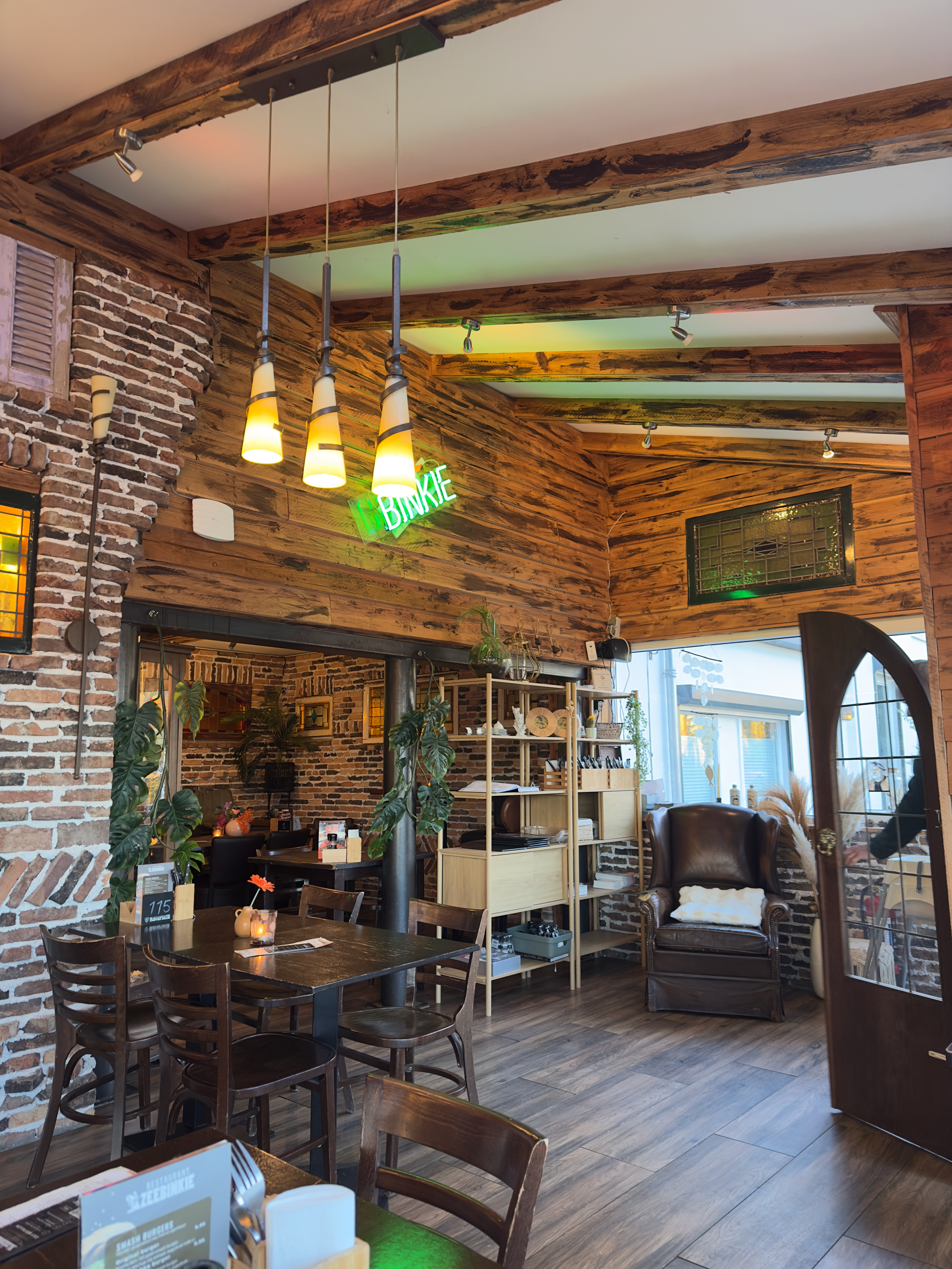 Restaurant Zeebinkie review, cozy interior of Restaurant Zeebinkie in Burgh Haamstede with wooden ceiling beams, exposed brick walls, warm pendant lighting and rustic Zeeland dining atmosphere