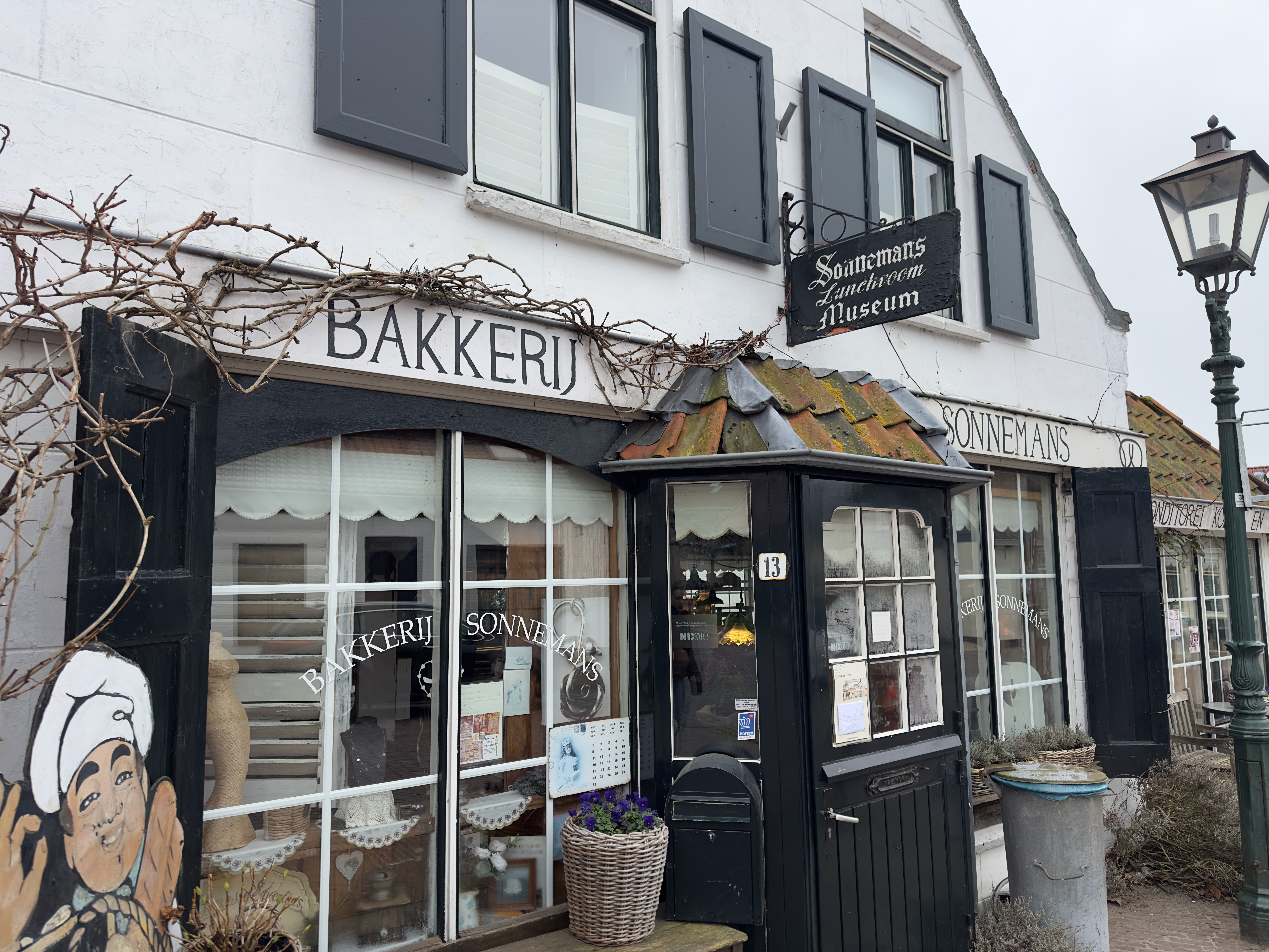 Bakkerij Sonnemans in Burgh Haamstede exterior at Hogeweg 13 with traditional white facade, black shutters, vintage bakery sign and rustic entrance under moss covered roof