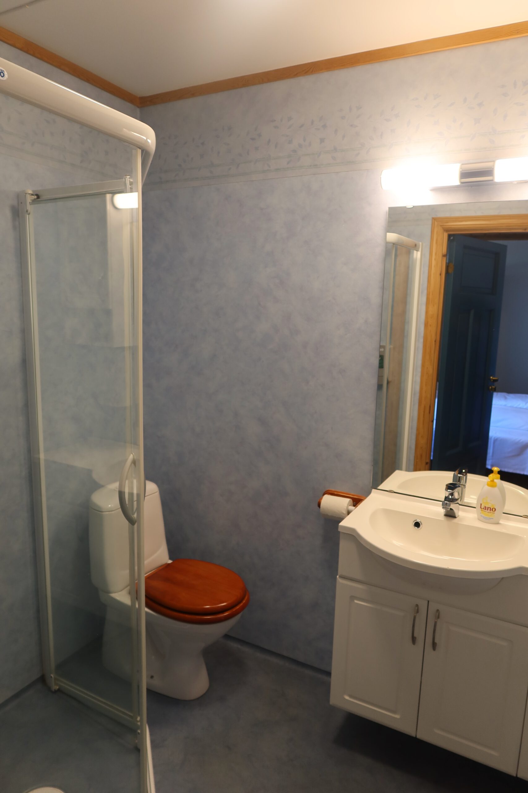 Private bathroom with shower and sink at Lødingen waterfront hotel Norway, clean and simple hotel bathroom interior in Northern Norway