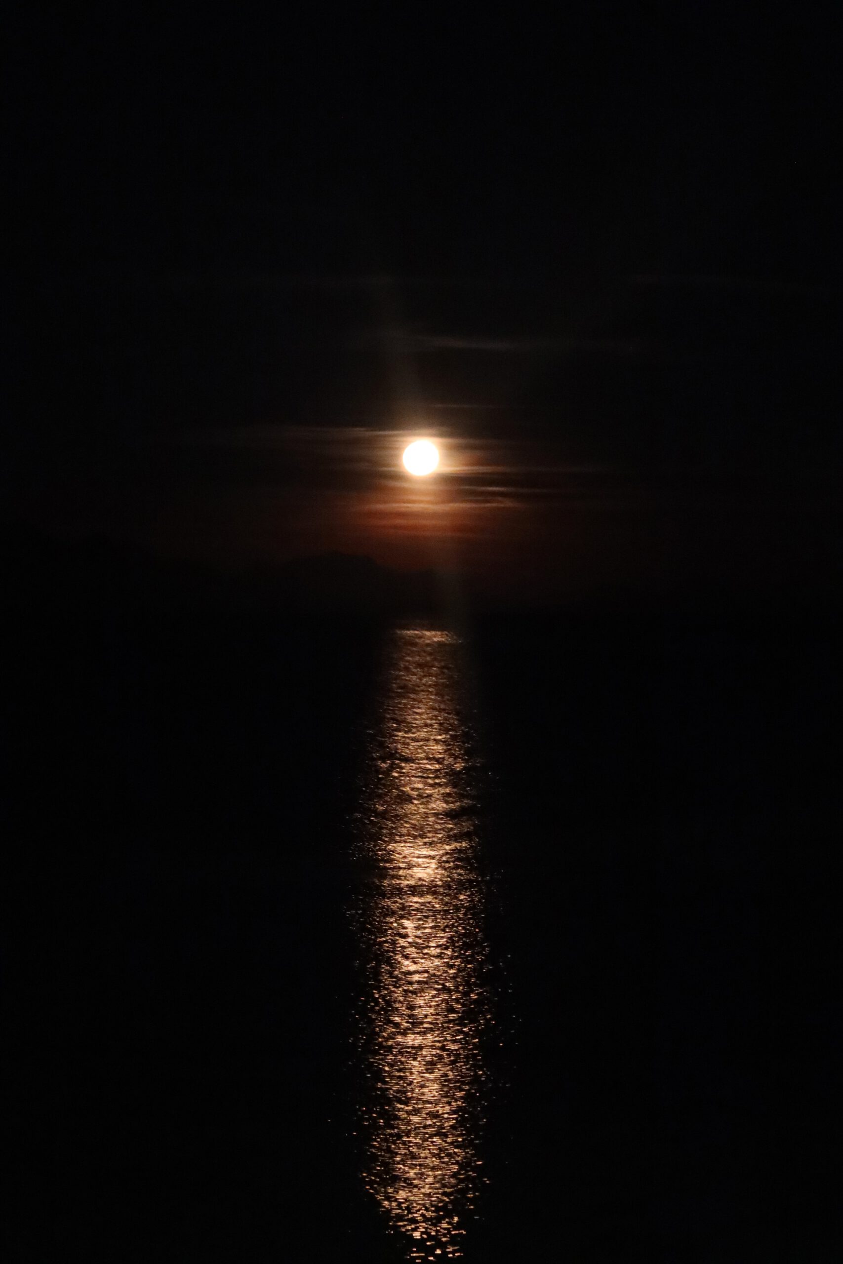 Moonlight over the sea at Hjertholmen island in Lødingen, full moon reflecting on calm water in Northern Norway, a quiet Arctic night after northern lights