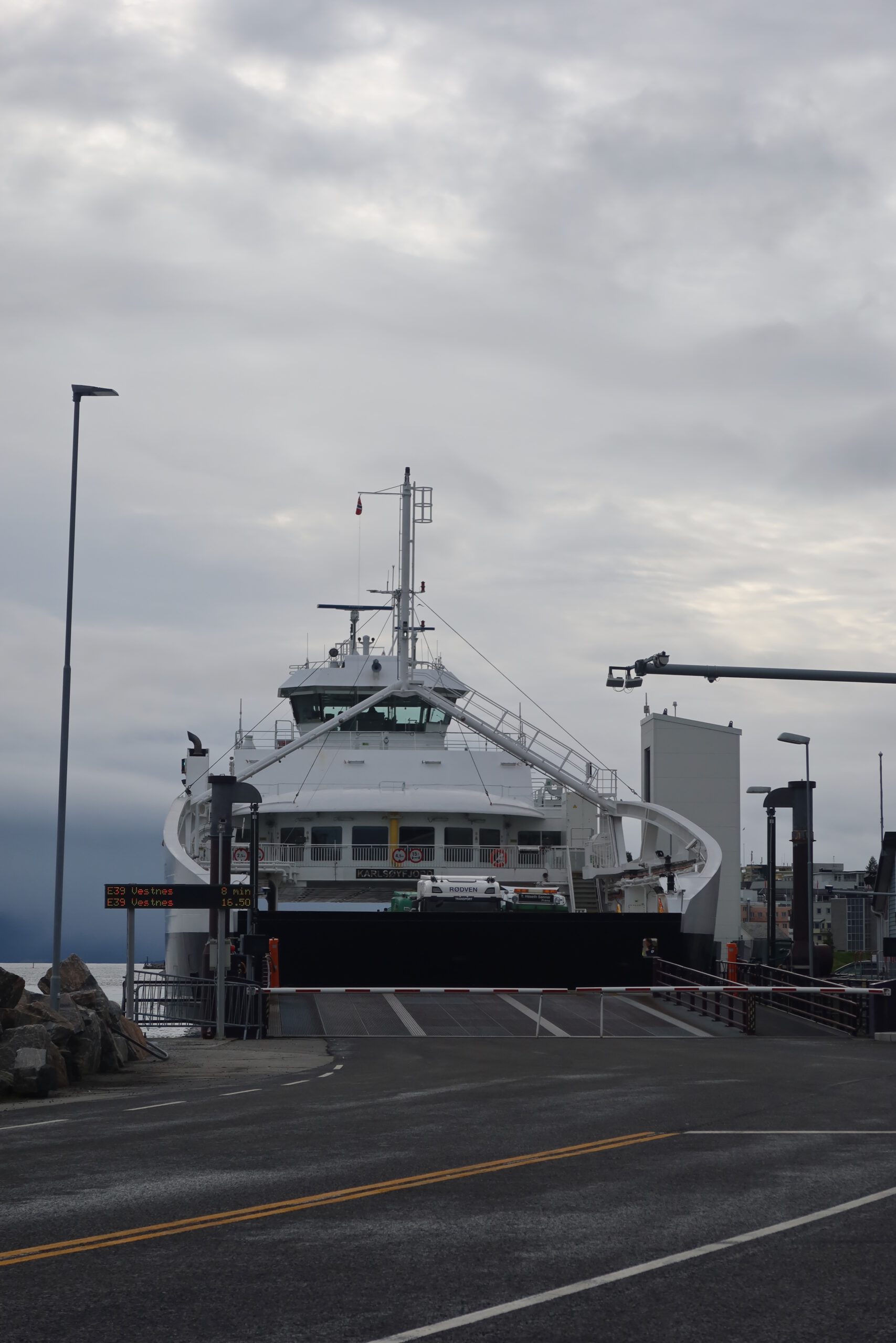 Molde to Vestnes ferry arriving at dock near Vestnes Fjordhotel under cloudy Norwegian fjord sky