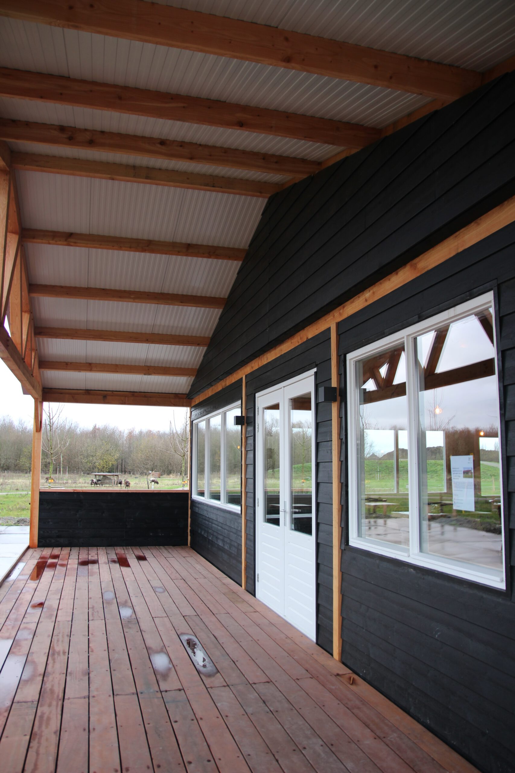 Covered terrace of BentGoud Bentwoud during the construction phase, showing the wooden deck, exterior walls, and surrounding Bentwoud landscape before opening