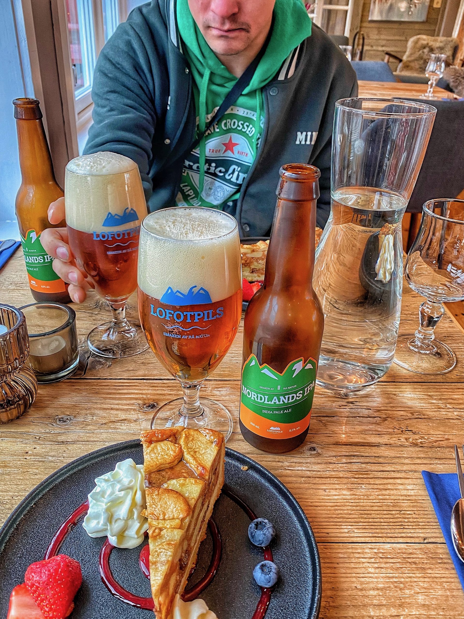 Å Rorbuer Lofoten restaurant dessert moment with cake whipped cream berries and local Lofoten beers served inside the dining room