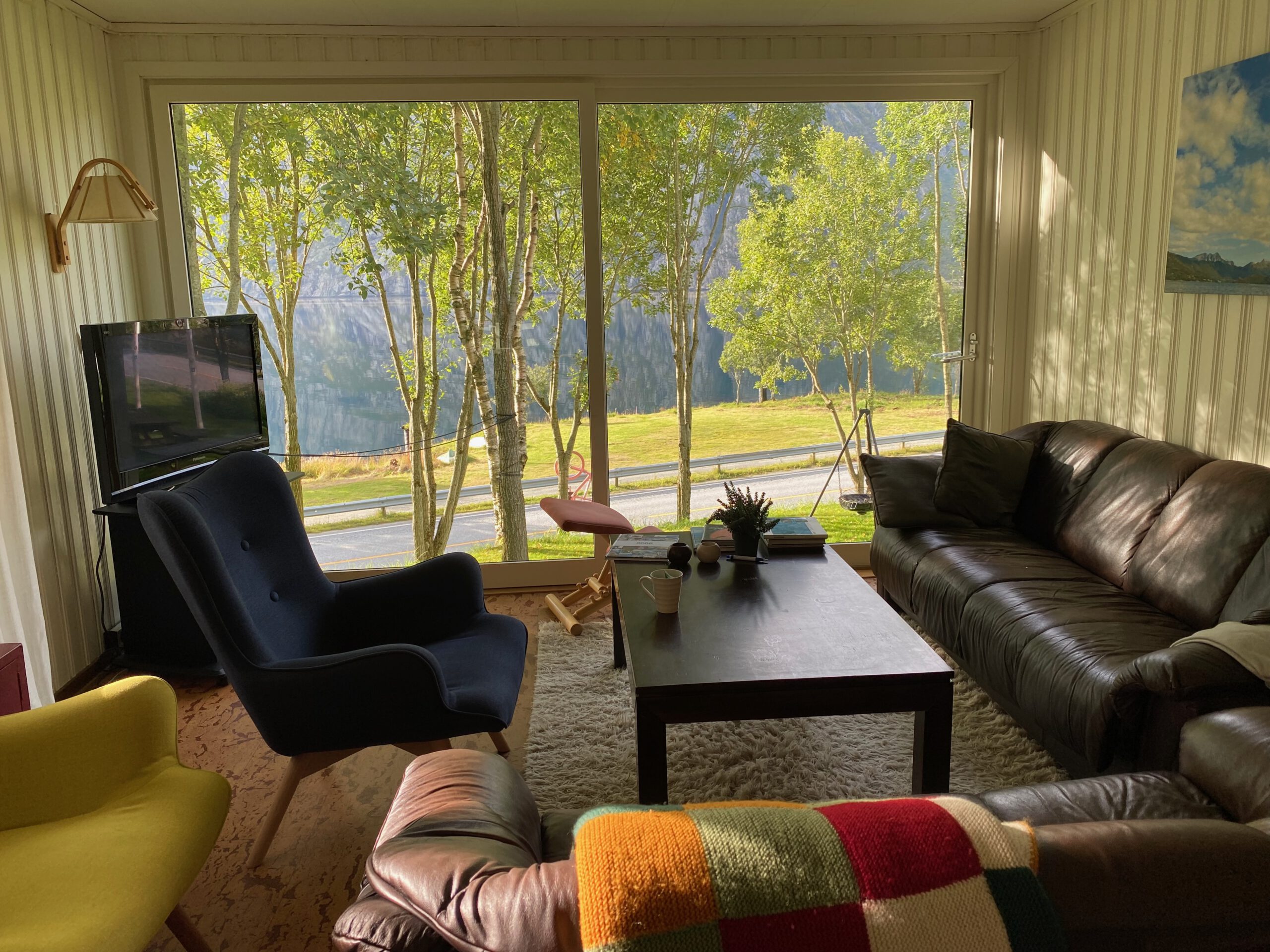 Gulbrakka Basecamp Glomfjord living room interior, cozy shared lounge with sofas, large windows and mountain and fjord views in Northern Norway