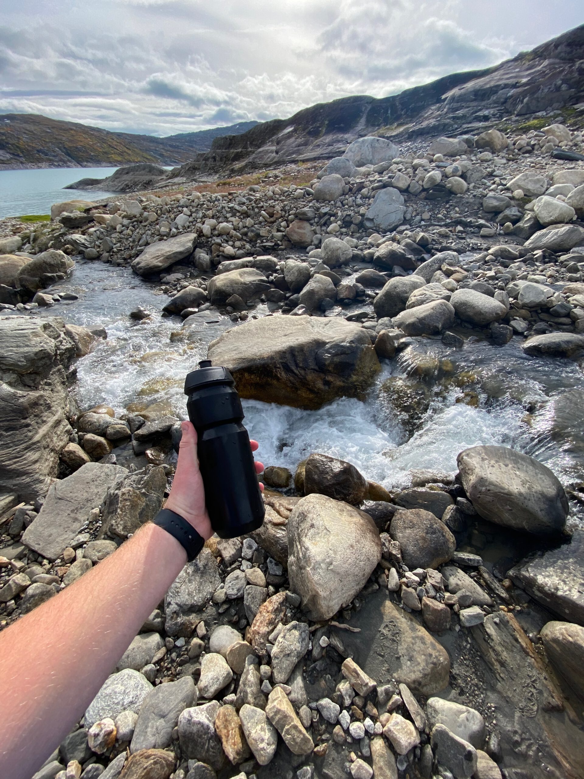 Glomfjord lake and dam adventure showing a glacier fed stream flowing over rocks, with clear meltwater near Storglomvatnet in Northern Norway