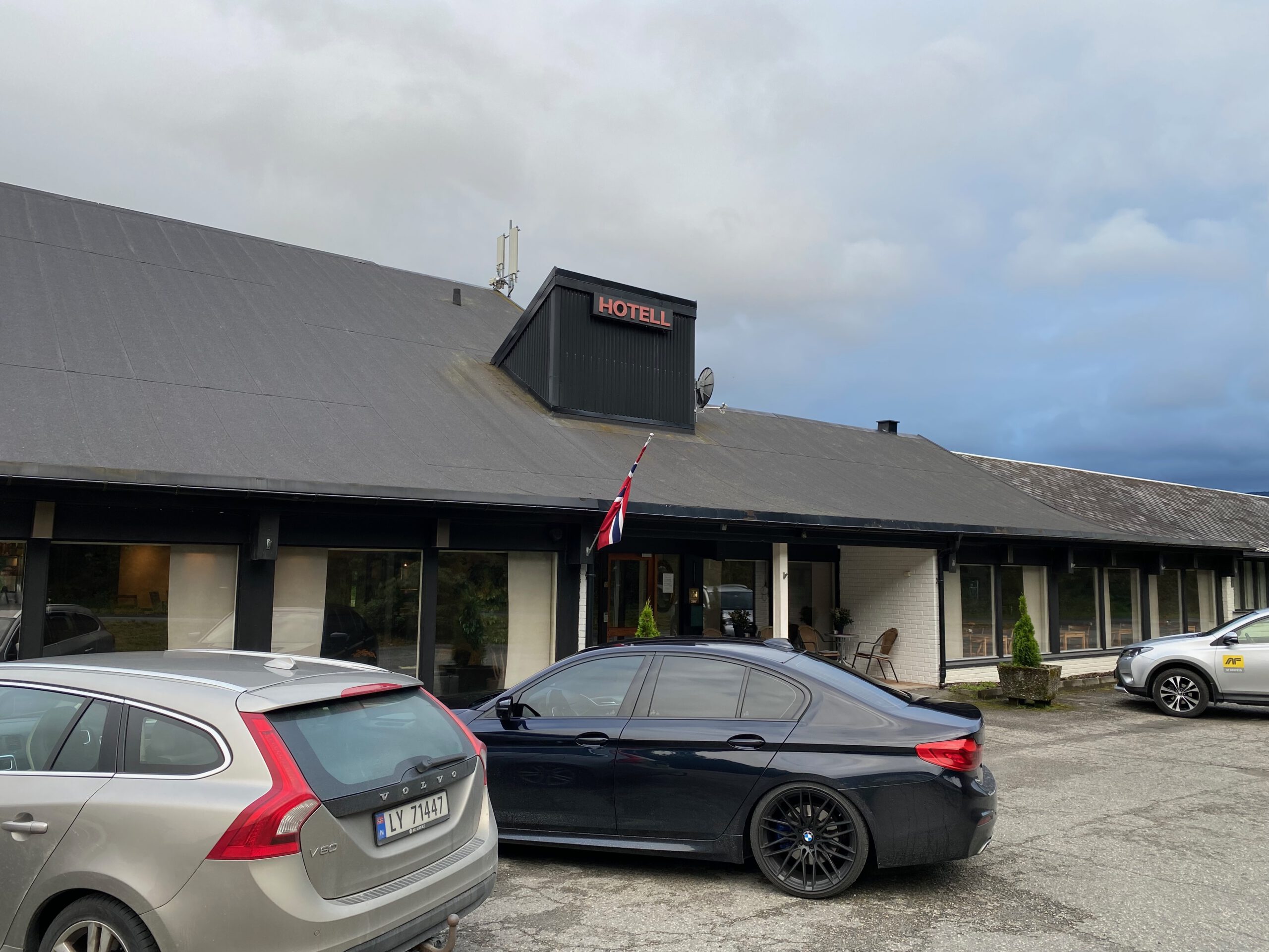 Støren Hotel Norway review exterior view with parking area on Engan 25 in Trøndelag, showing the hotel entrance and cars parked in front along the E6 road trip route