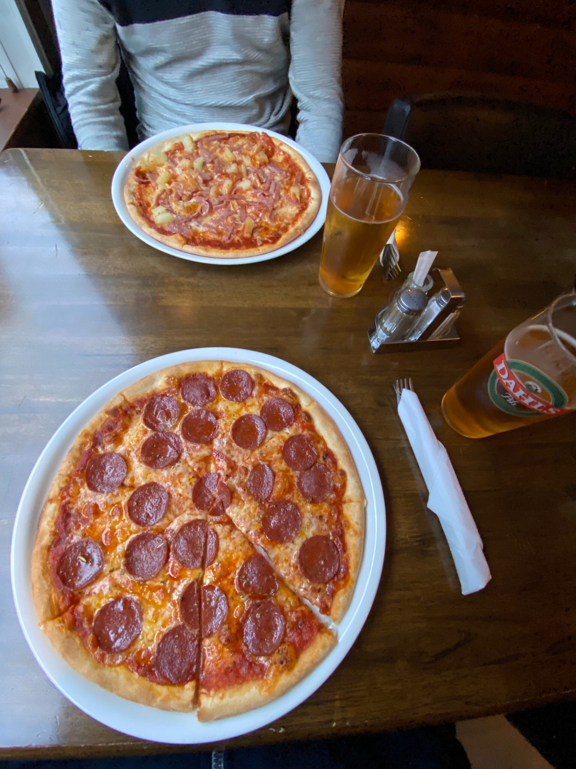 Torino Restaurant Støren pizza dinner in Støren Norway, pepperoni pizza and Hawaii pizza with ham and pineapple served with pils beer on wooden table