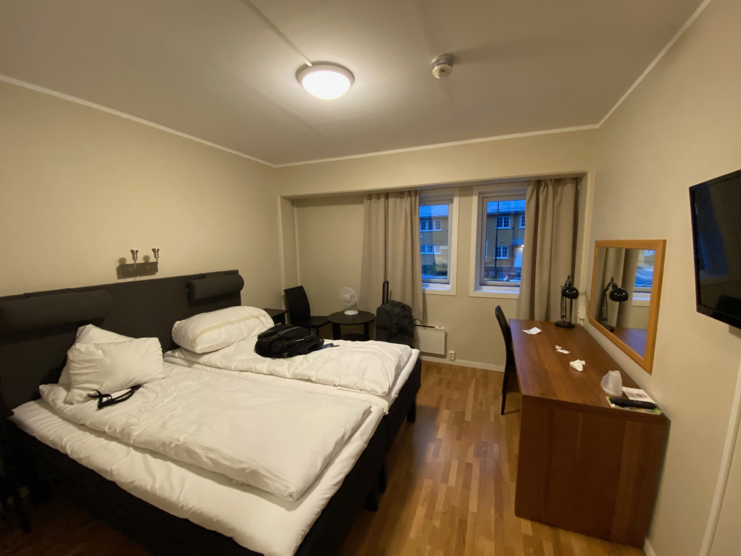 Støren Hotel Norway review double room interior in Trøndelag, showing twin beds, wooden desk, TV, minibar and window view near the E6 road trip route