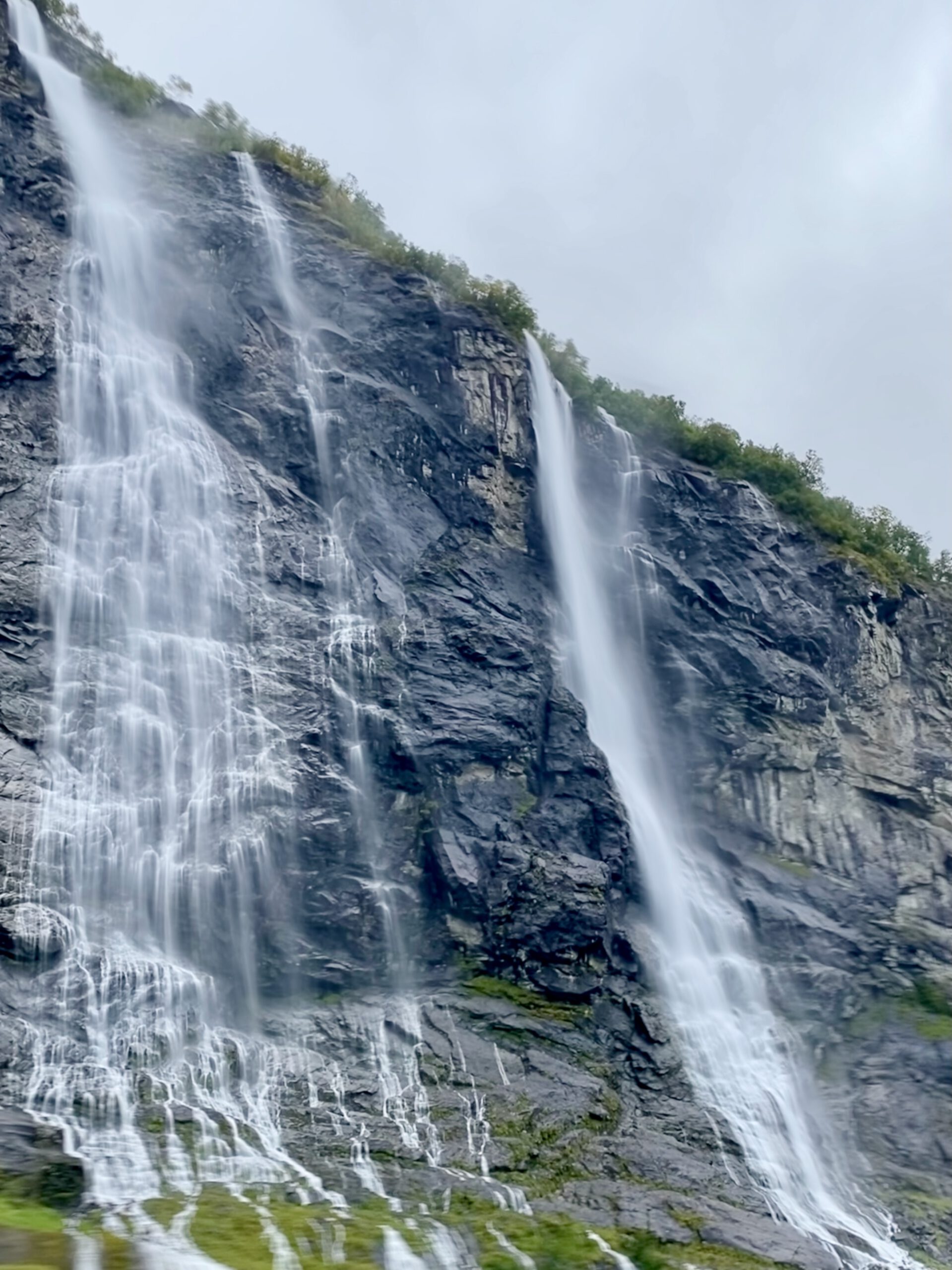 Close view of Seven Sisters waterfall in Geirangerfjord during the Geiranger Fjord and Waterfalls Sightseeing Boat Trip with dramatic rock cliffs and mist