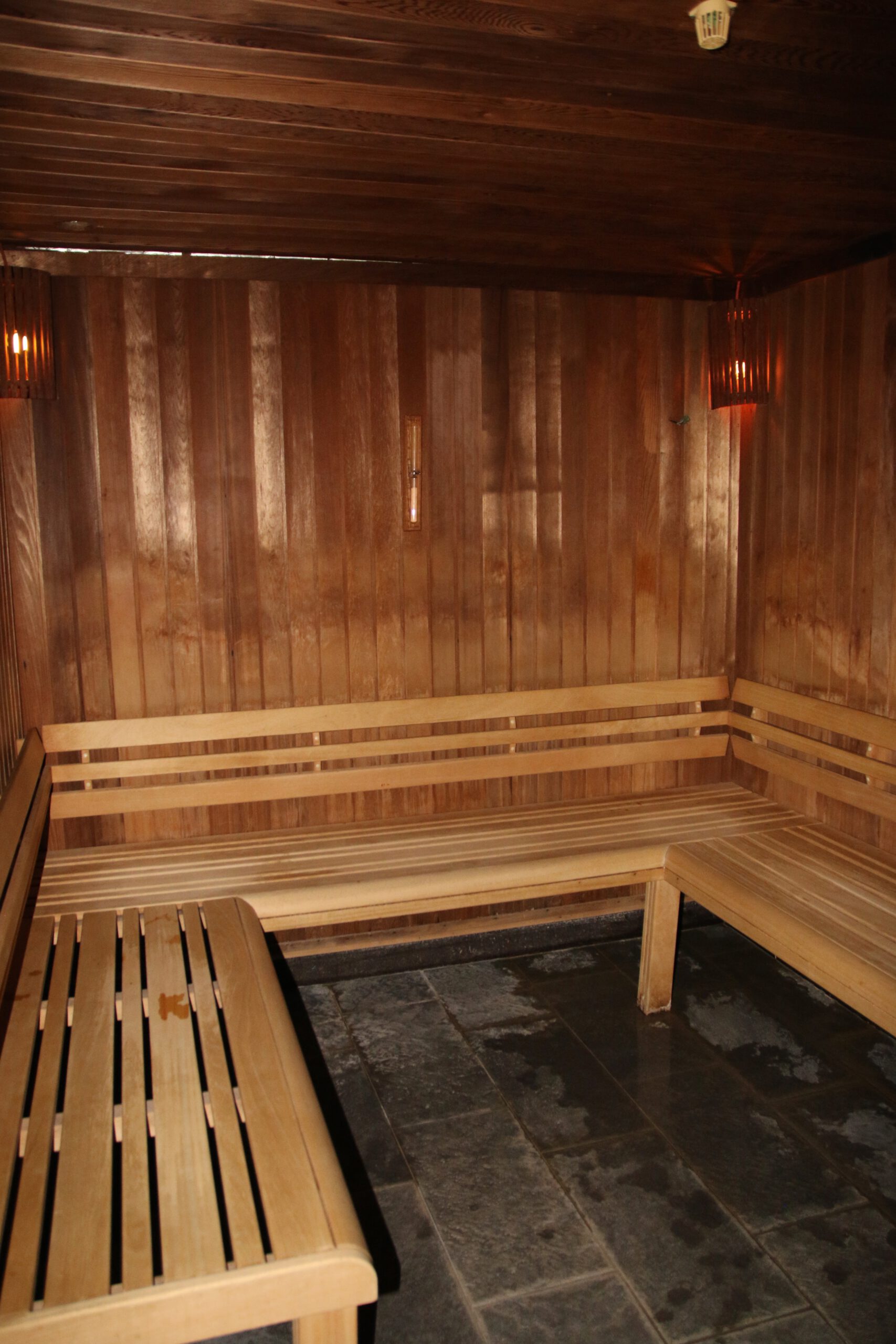 Grand Hotel Ter Duin review wooden sauna interior in the hotel spa featuring bench seating, warm lighting, and traditional wellness design