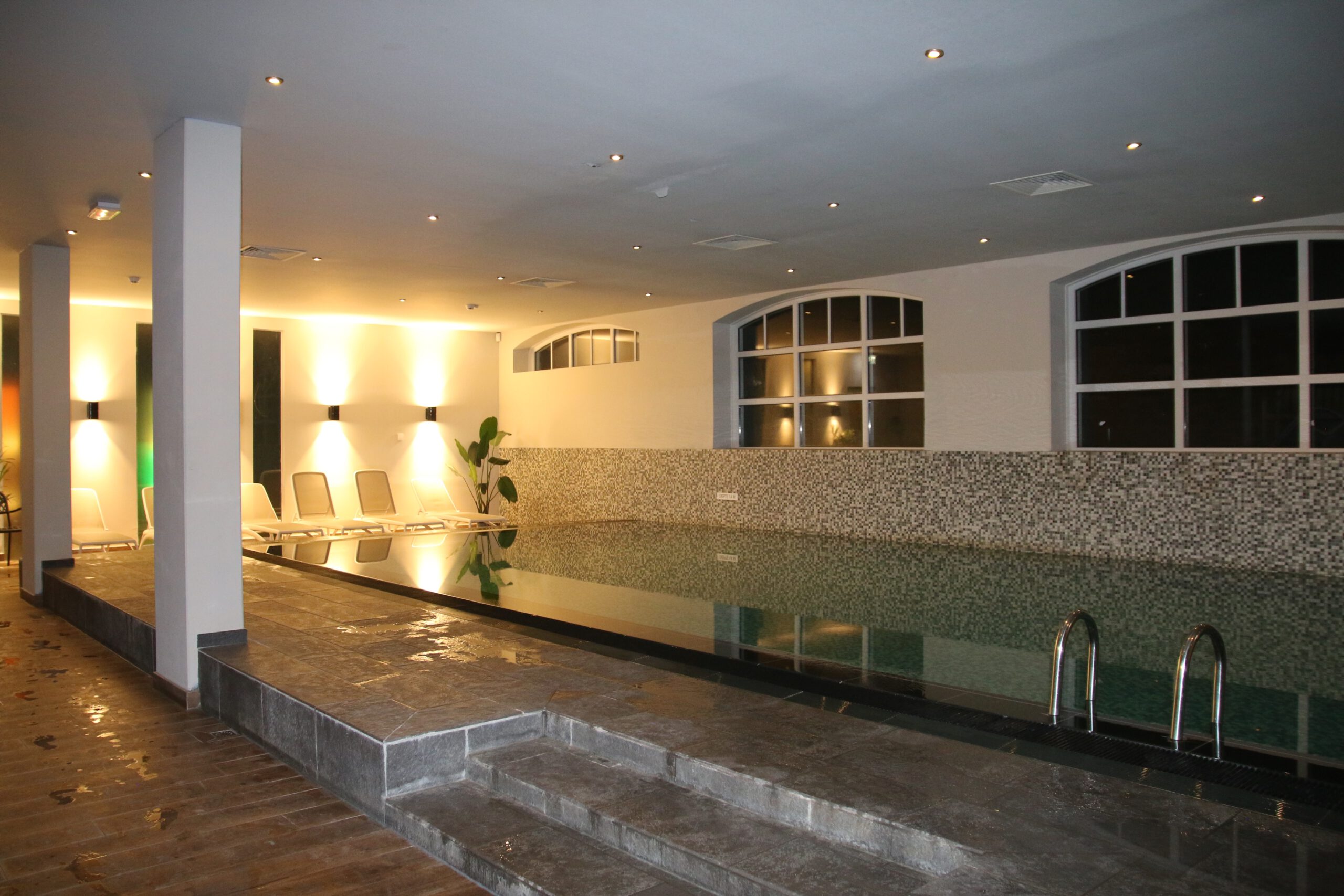 Grand Hotel Ter Duin spa review – warm indoor swimming pool with soft ambient lighting, tiled edges and lounge chairs inside the wellness area of Grand Hotel Ter Duin in Burgh-Haamstede.