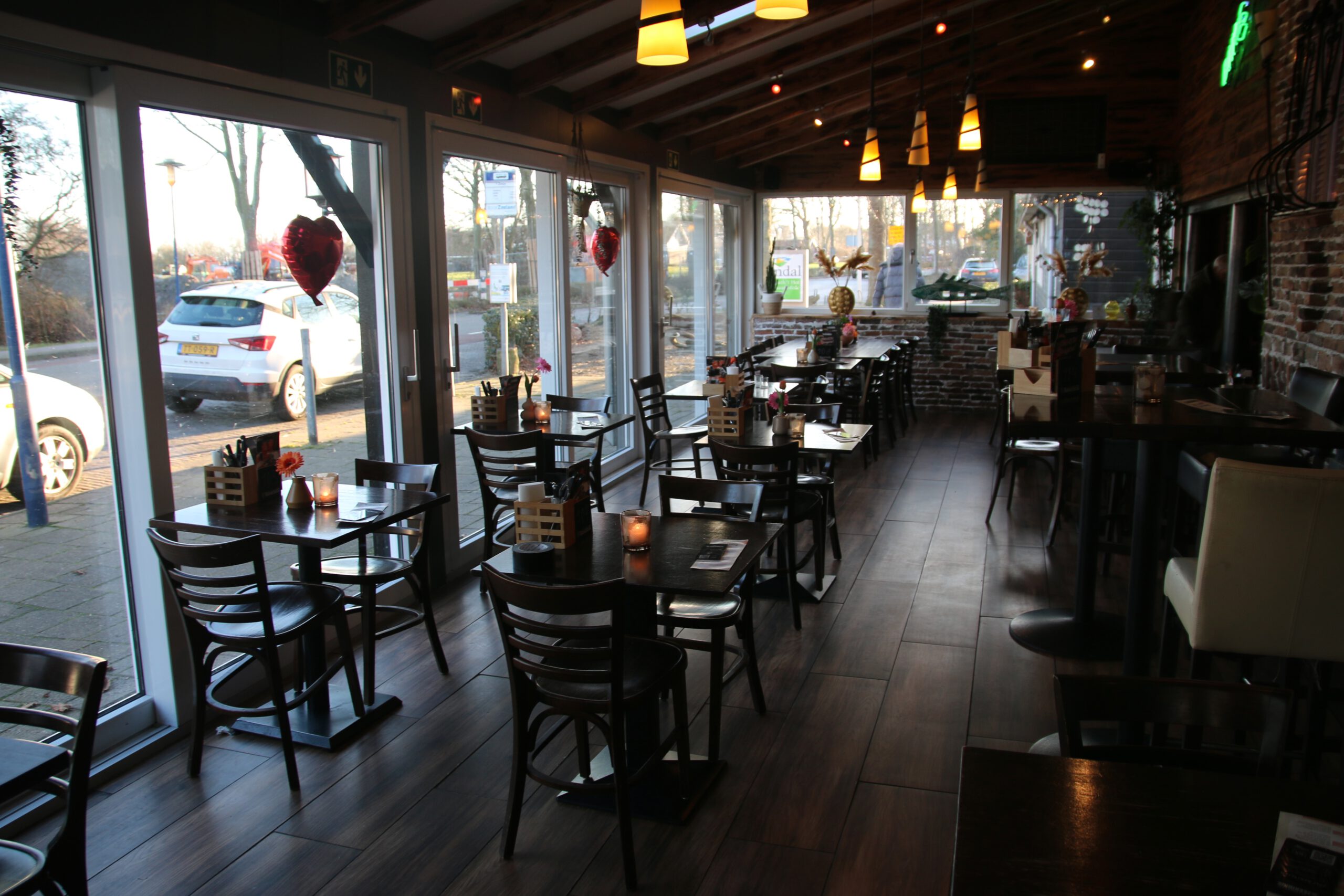 Restaurant Zeebinkie review, warm dining area of Restaurant Zeebinkie in Burgh Haamstede with large windows, wooden tables, candlelight and relaxed Valentine’s evening ambiance in Zeeland