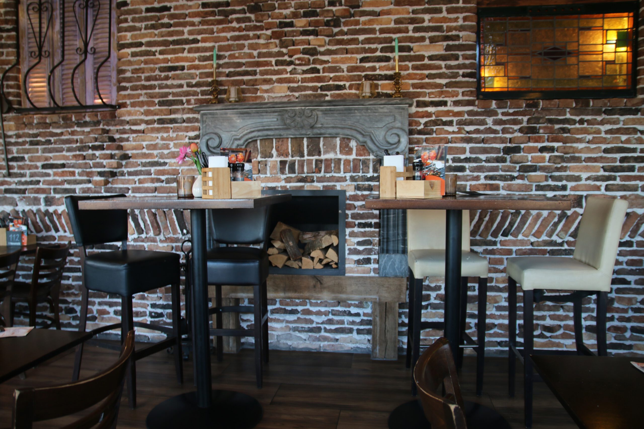 Restaurant Zeebinkie review, cozy interior of Restaurant Zeebinkie in Burgh Haamstede with exposed brick wall, decorative fireplace, high tables and warm rustic Zeeland atmosphere