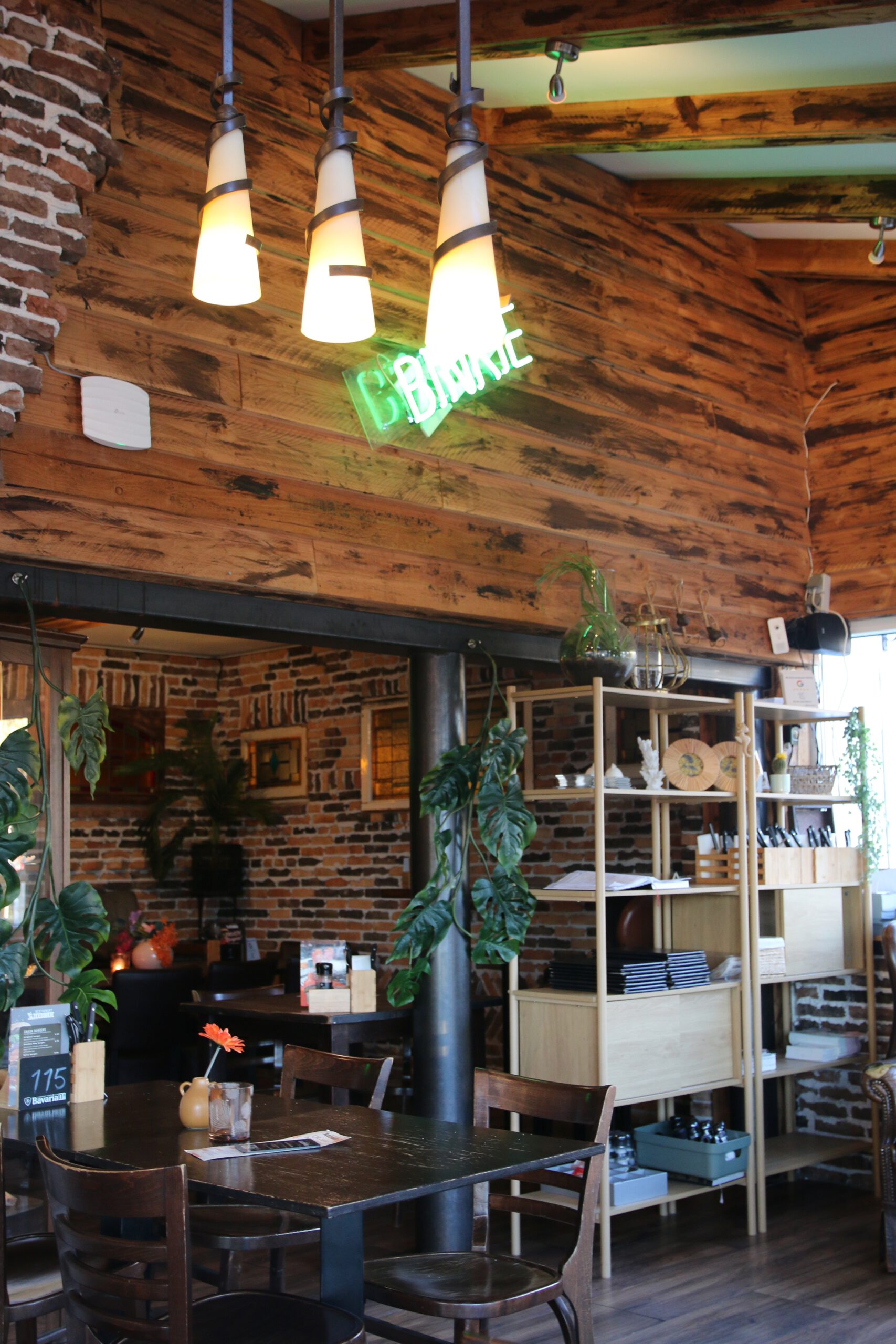 Restaurant Zeebinkie review, neon Binkie sign inside Restaurant Zeebinkie in Burgh Haamstede with wooden wall panels, hanging lamps, brick accents and intimate dining tables in Zeeland