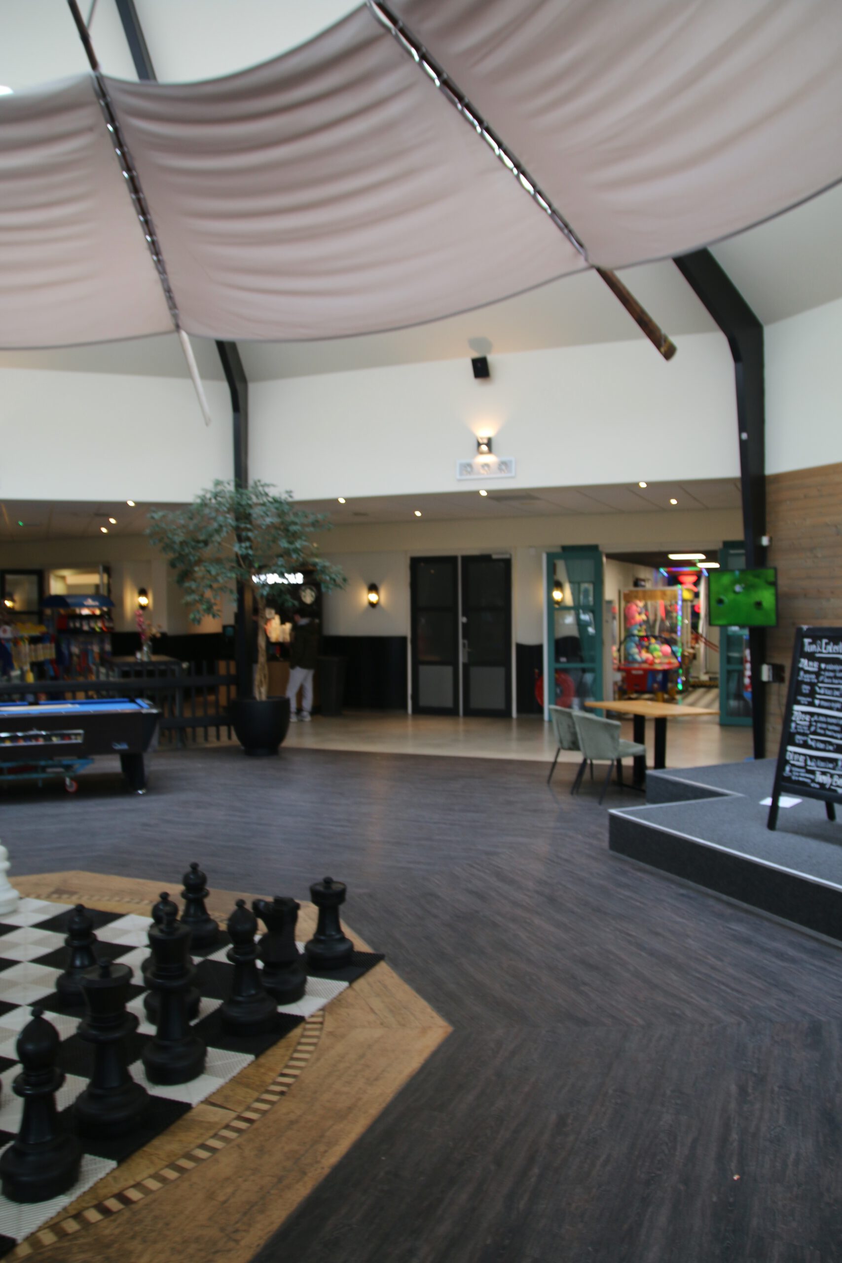 Landal Noordzee Résidence De Banjaard Plaza interior in Kamperland, Zeeland, indoor chess board, pool table and arcade area for families