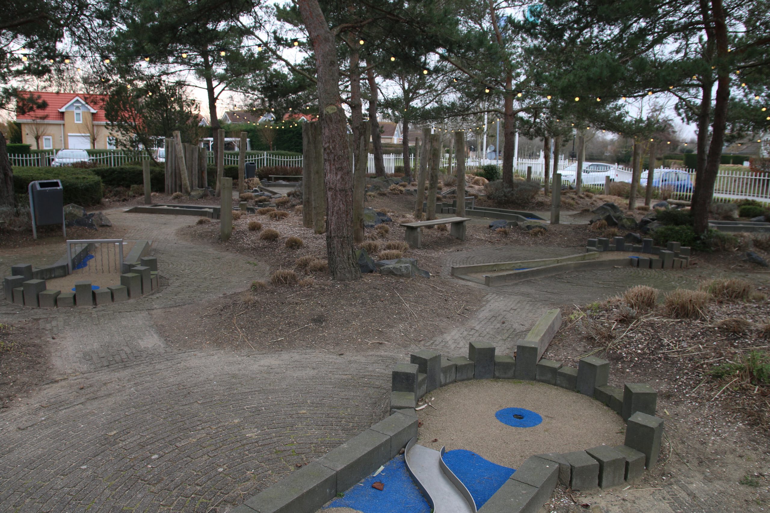 Landal Noordzee Résidence De Banjaard mini golf course in Kamperland, Zeeland, outdoor family activity area surrounded by trees and cozy park lighting