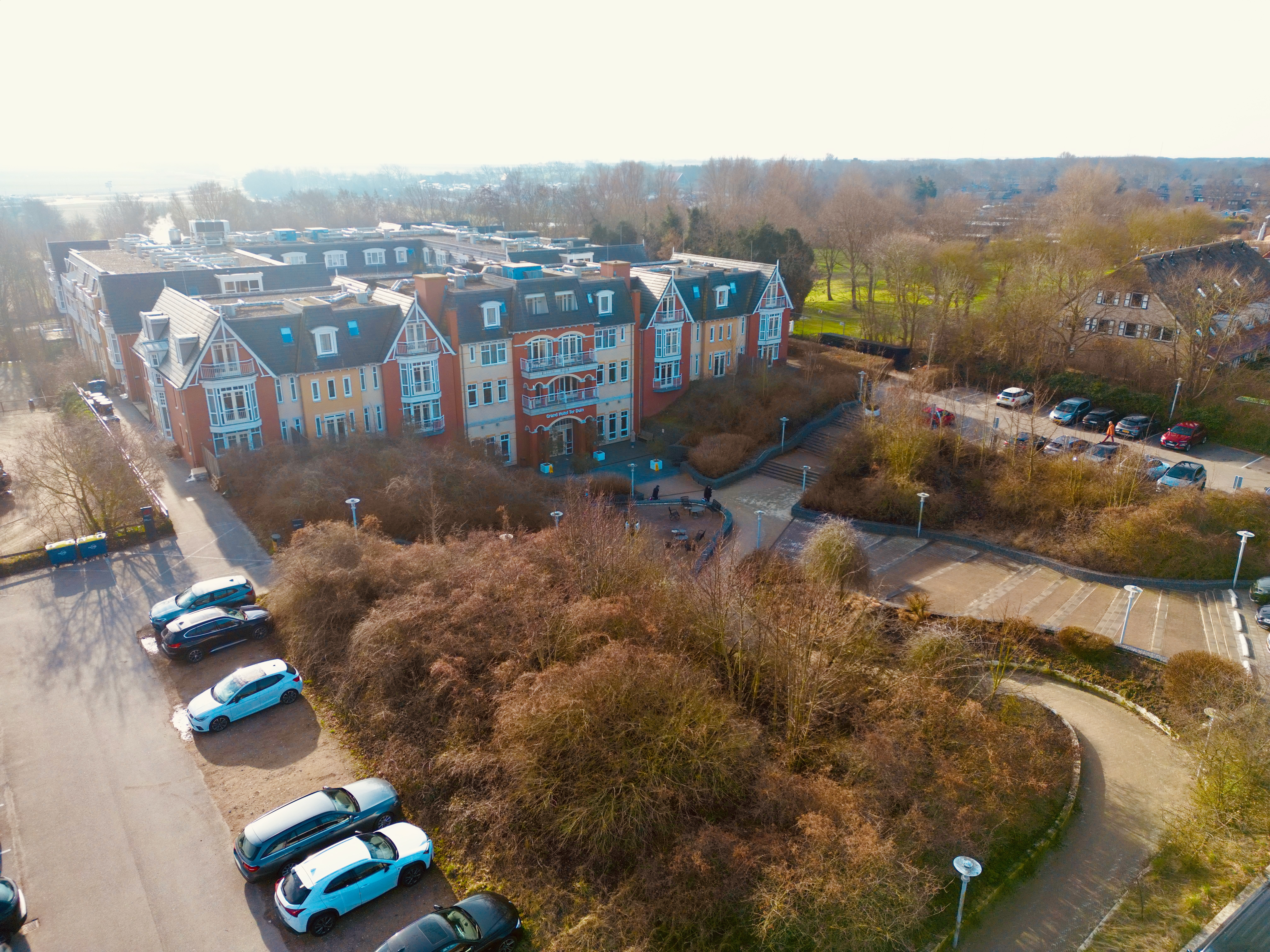 Grand Hotel Ter Duin review drone view showing the full hotel building in Burgh Haamstede with parking area, surrounding greenery, and winter landscape from above