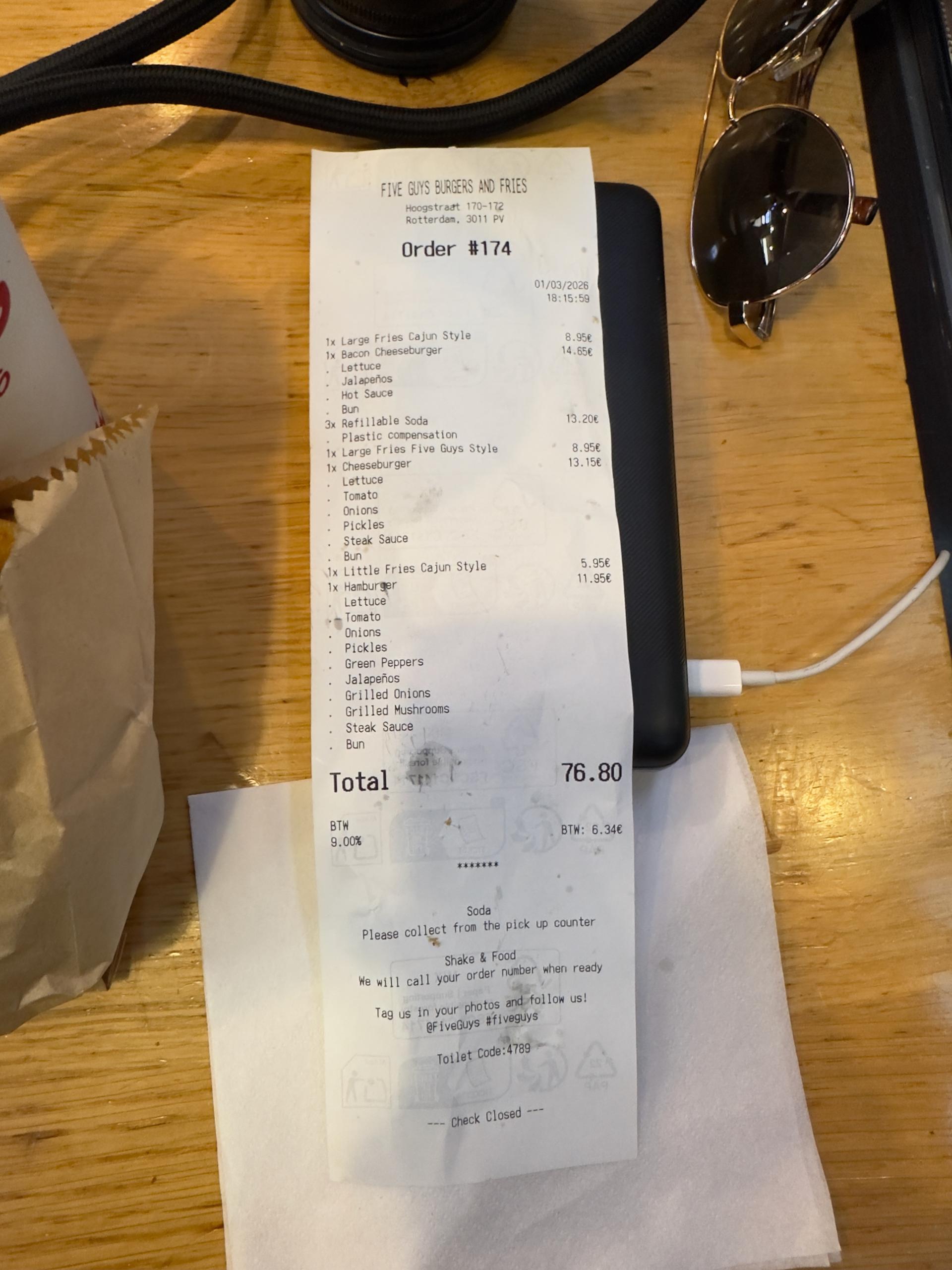Receipt from Five Guys Netherlands in Rotterdam after Pokémon GO Tour Kalos Global, showing three burgers, three fries, refillable sodas, and a total of €76.80 including VAT.
