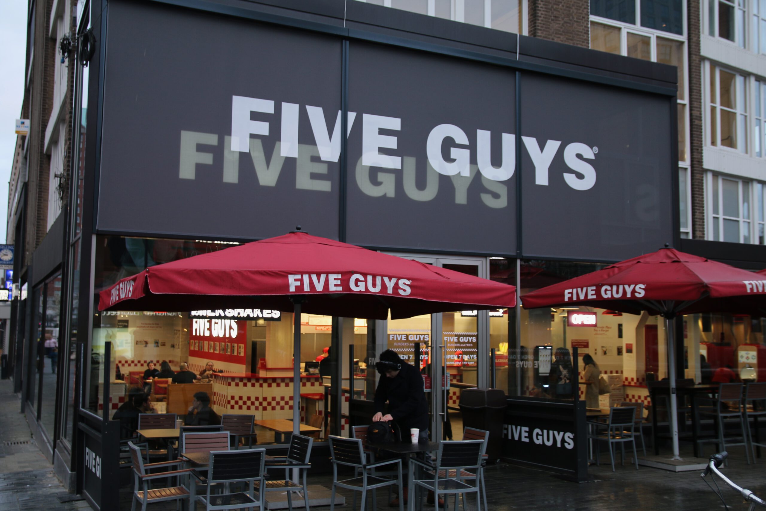 Five Guys Netherlands restaurant exterior in Rotterdam with red umbrellas and American style branding after Pokémon GO Tour Kalos Global.