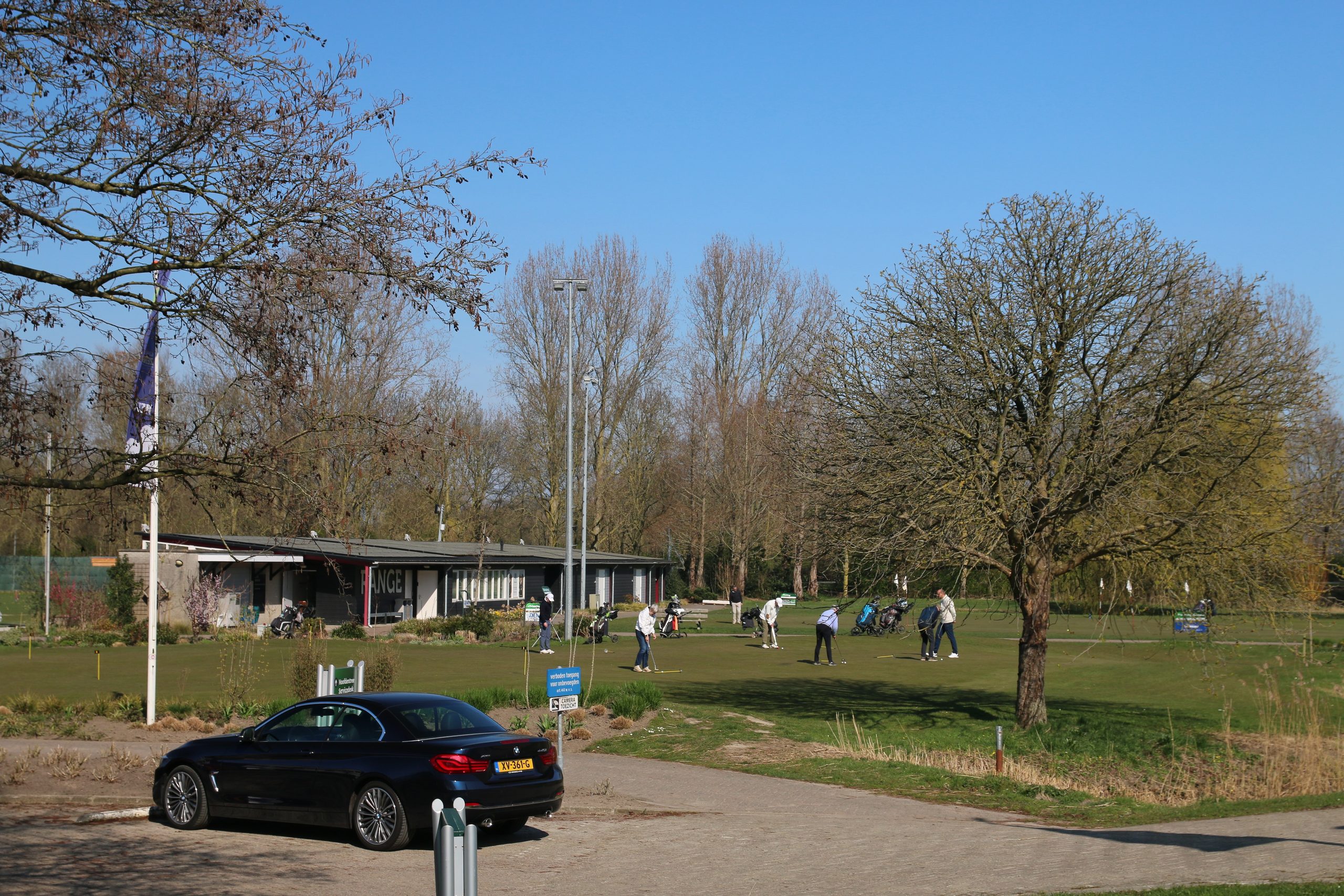Golfclub Zeegersloot practice green and clubhouse area in Alphen aan den Rijn with golfers on a sunny day