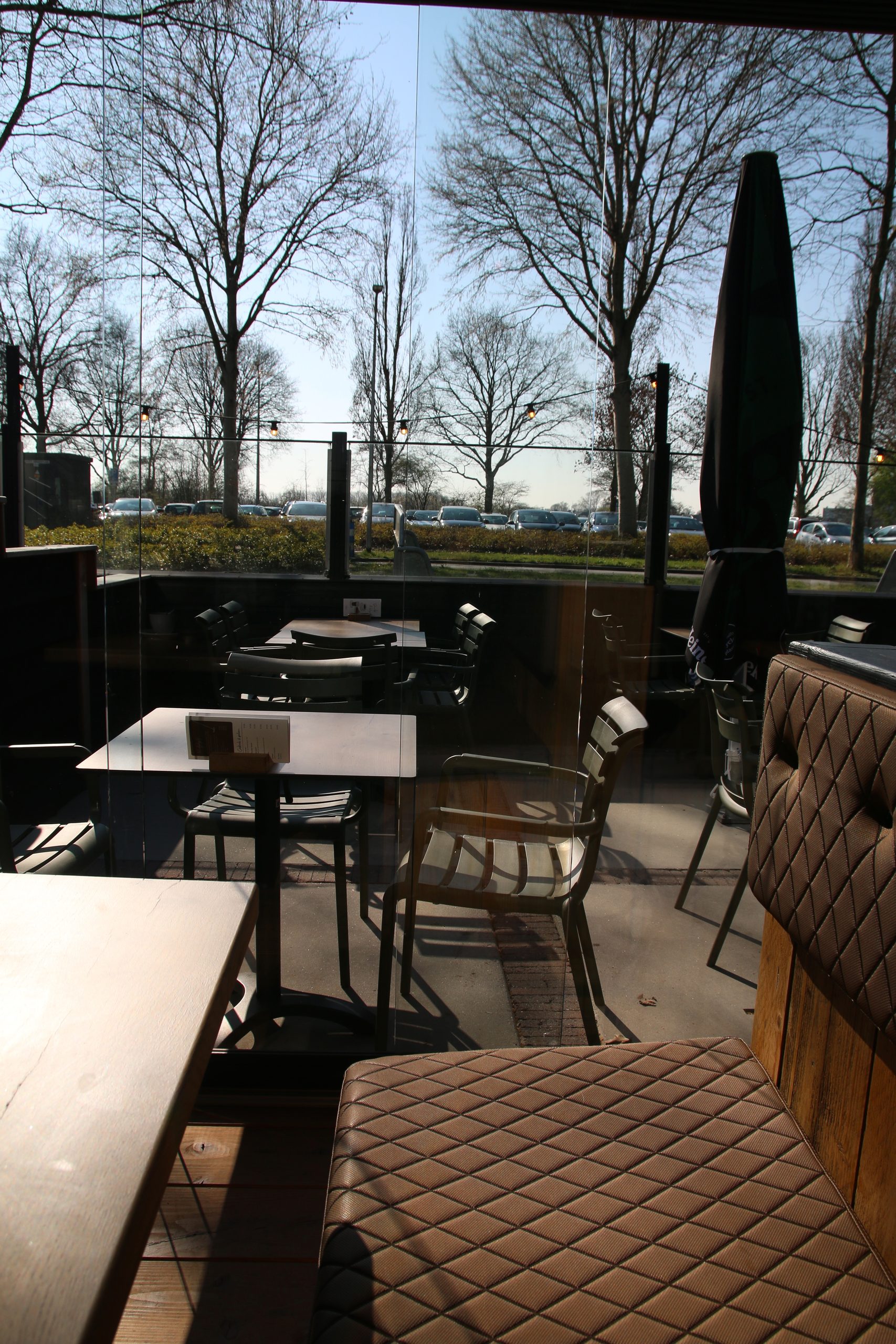 Bij Hen Alphen aan den Rijn enclosed terrace seating with glass walls and a sunny outdoor view in Park Zegersloot