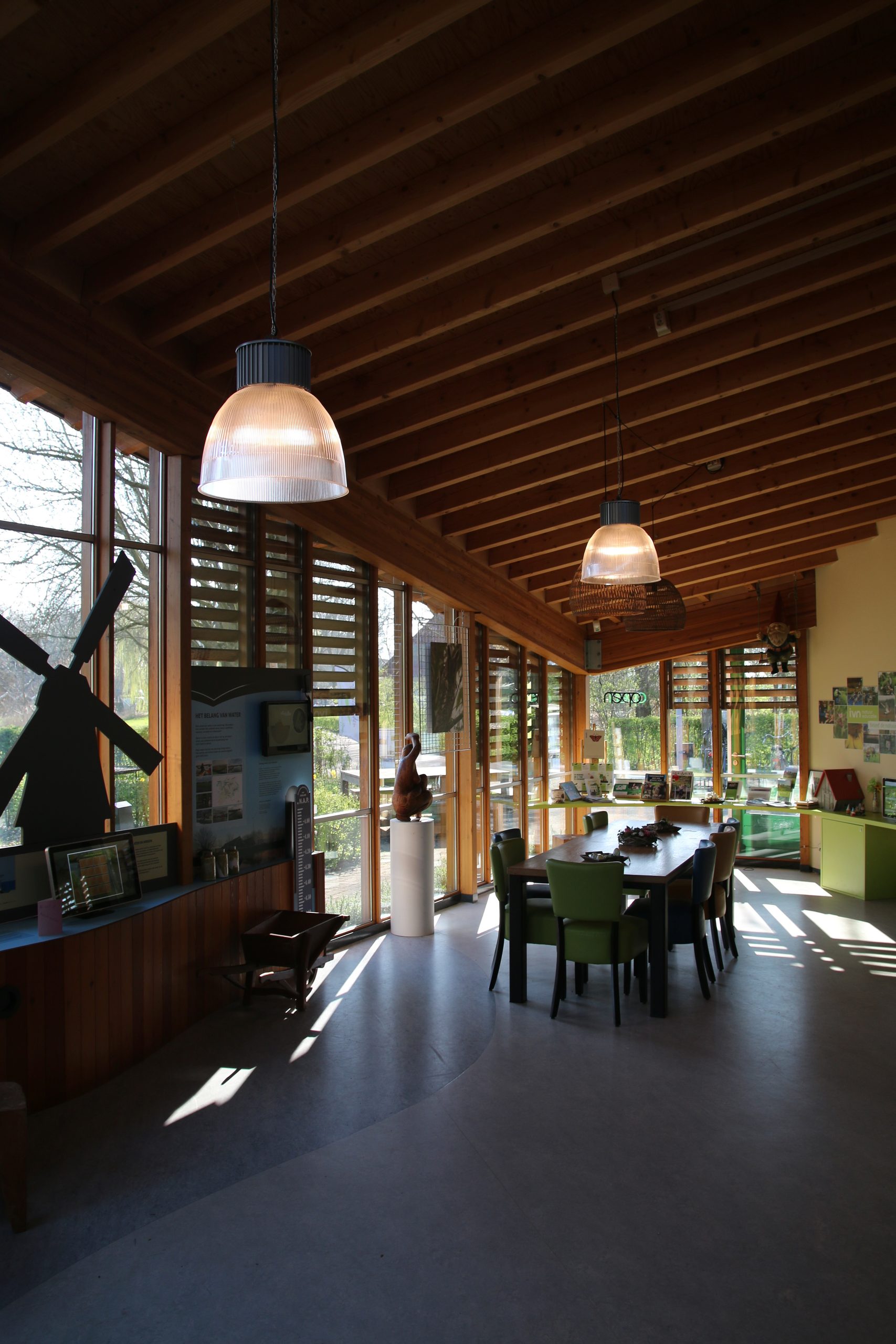 Bezoekerscentrum De Veenweiden interior with wooden ceiling, natural light, exhibition displays, and a welcoming visitor space in Alphen aan den Rijn