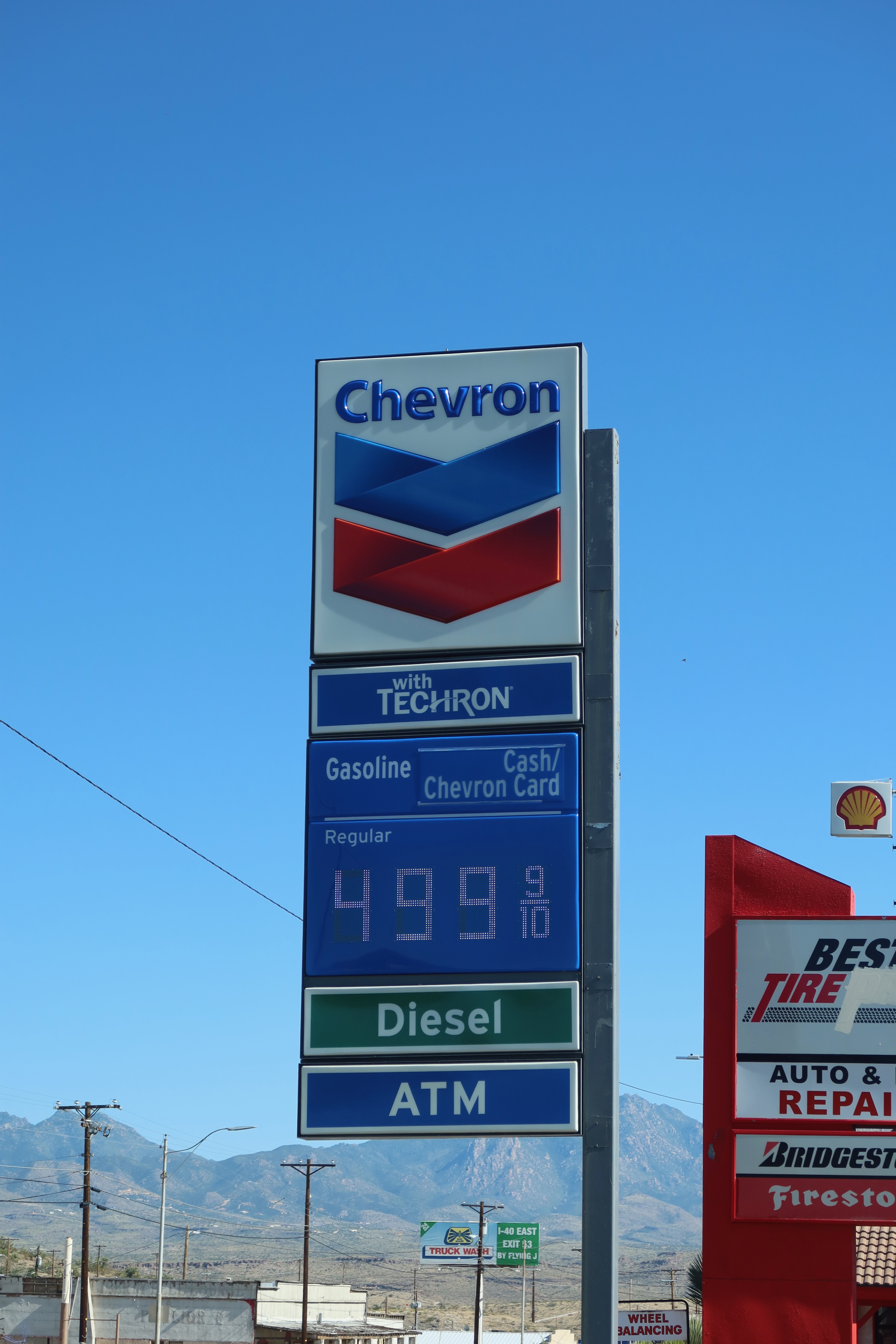 Gas stations in America, Chevron fuel price sign with mountain backdrop and roadside services in the American West