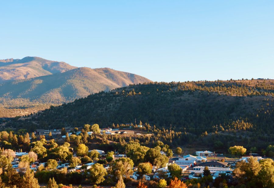 John Day Oregon guide header image showing the small town of John Day surrounded by sunlit hills and mountain scenery in Eastern Oregon