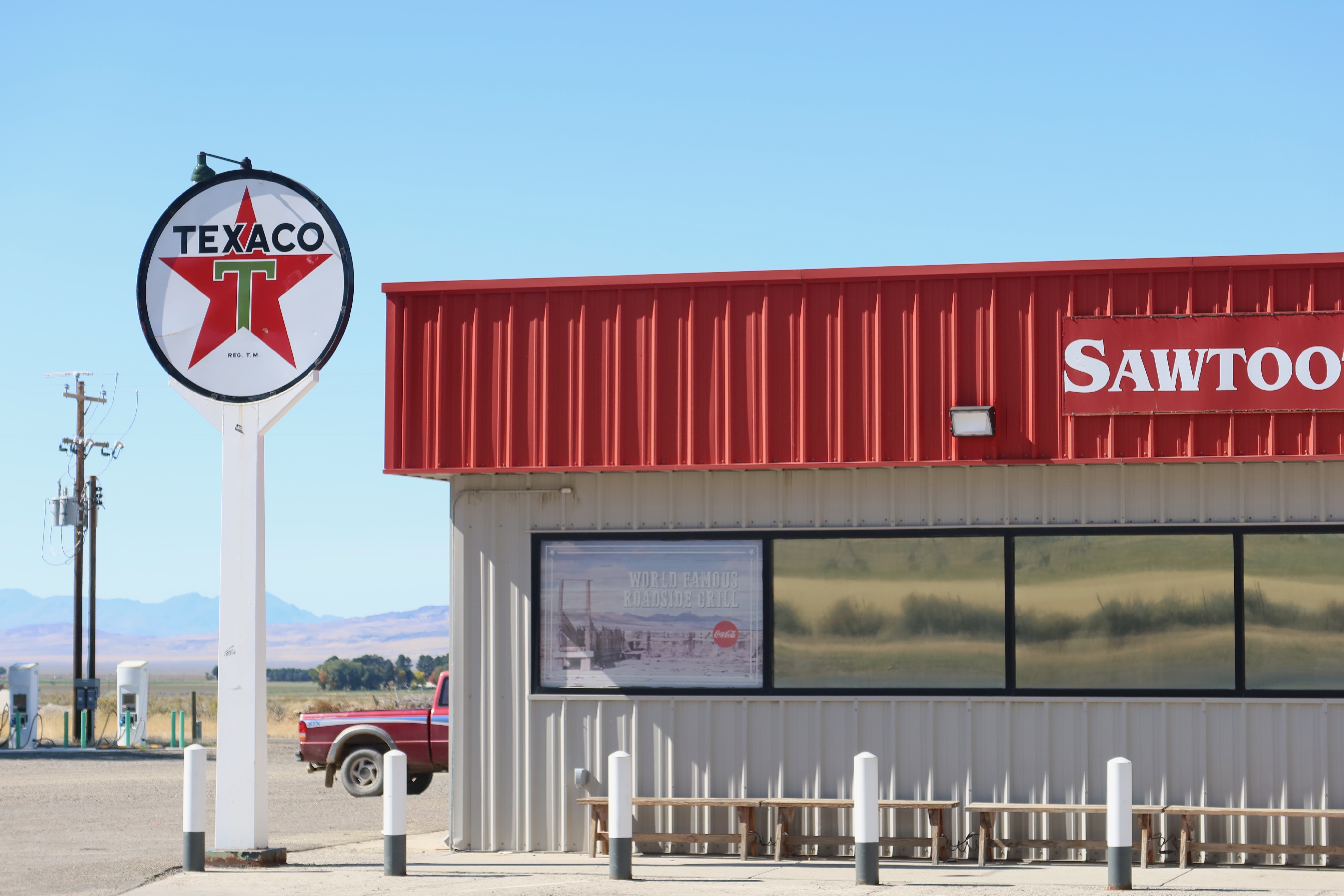 Gas stations in America, vintage Texaco sign next to a rural roadside store in the American West with pickup truck and open landscape