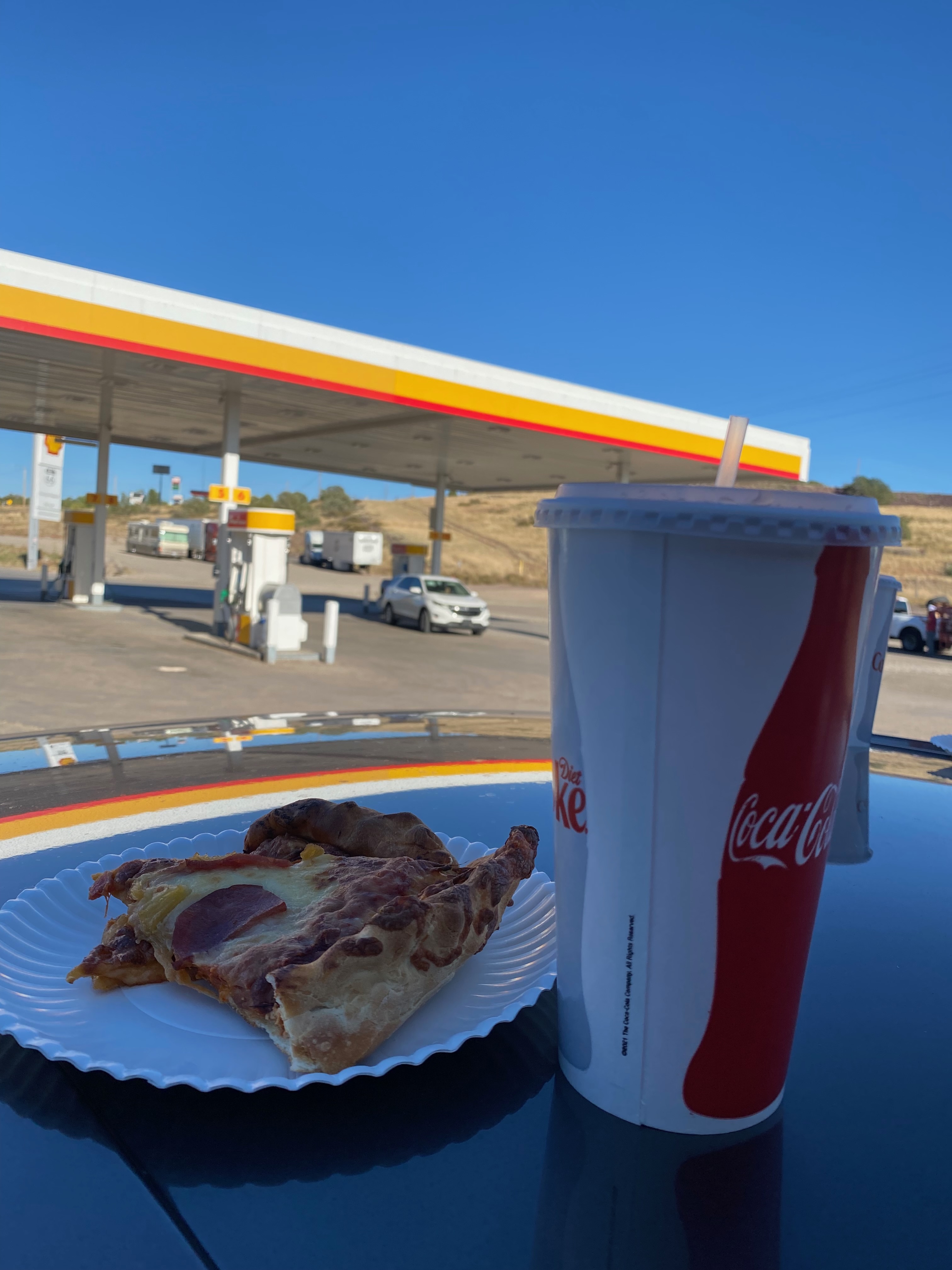 Gas stations in America, pizza slice and large soda at a Shell roadside stop in the American West during the USA road trip fuel stops