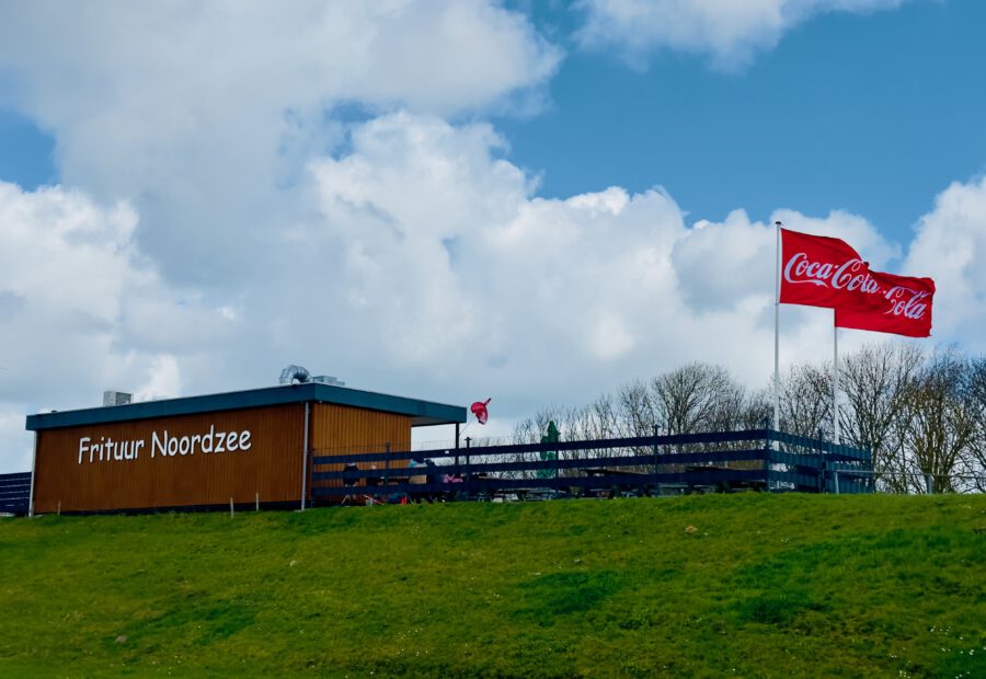 Frituur Noordzee Kamperland exterior with Coca Cola flags in Zeeland