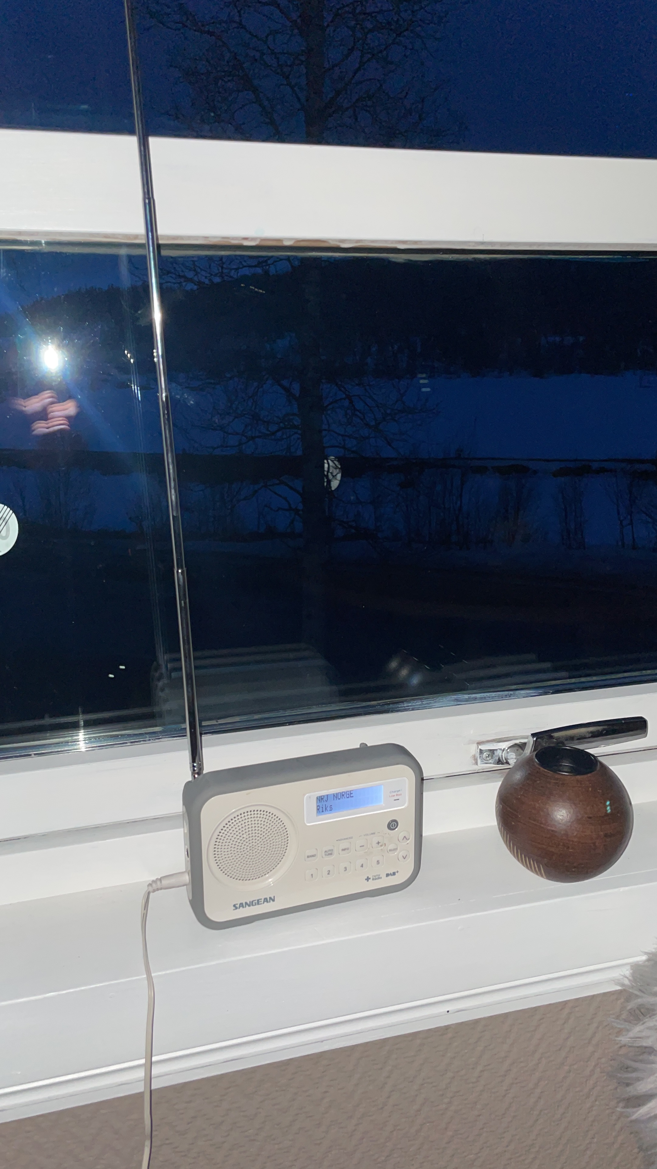 Northern Sweden Airbnb review, Sangean radio on a windowsill with snowy Swedish landscape visible outside during a quiet evening in the Airbnb