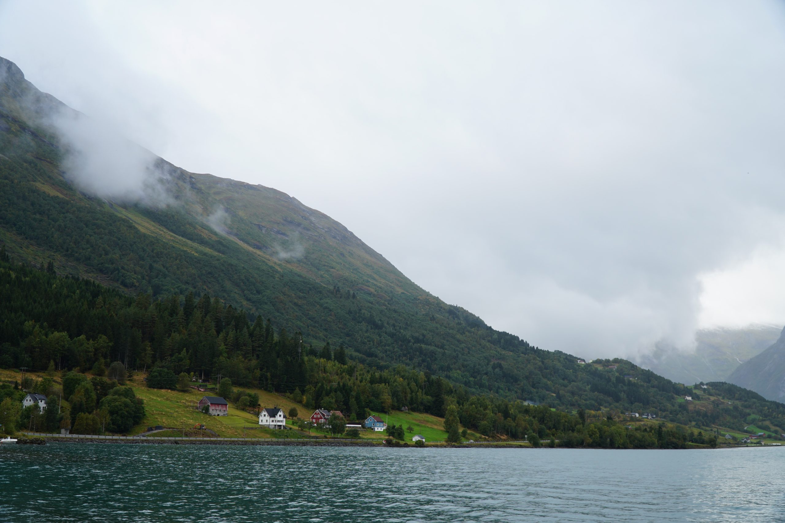 Jostedalsbreen National Park Center area with green mountain slopes, low clouds and lake views in Oppstryn Norway