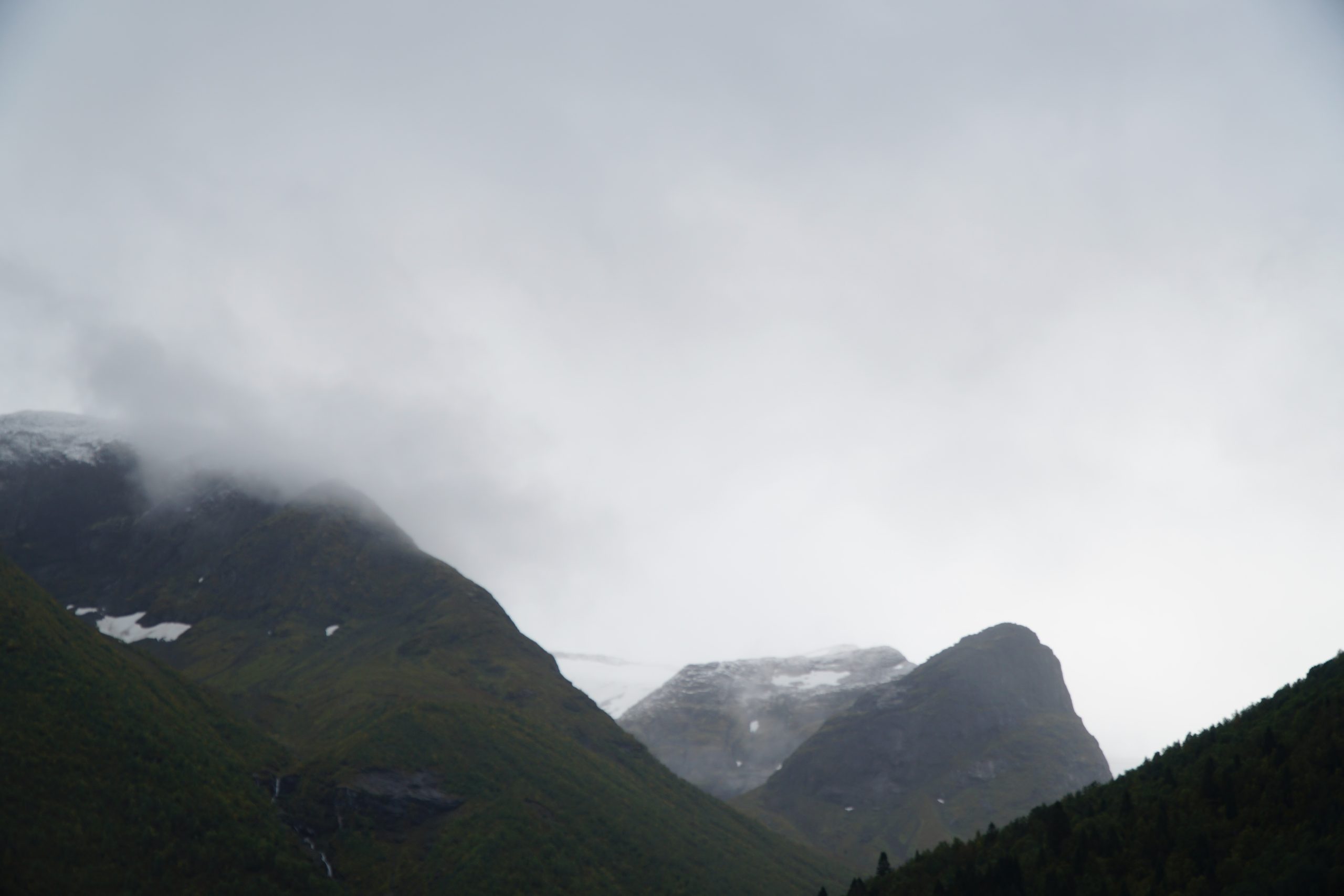 Jostedalsbreen National Park Center mountain view with distant glacier ice partly hidden behind clouds in Norway