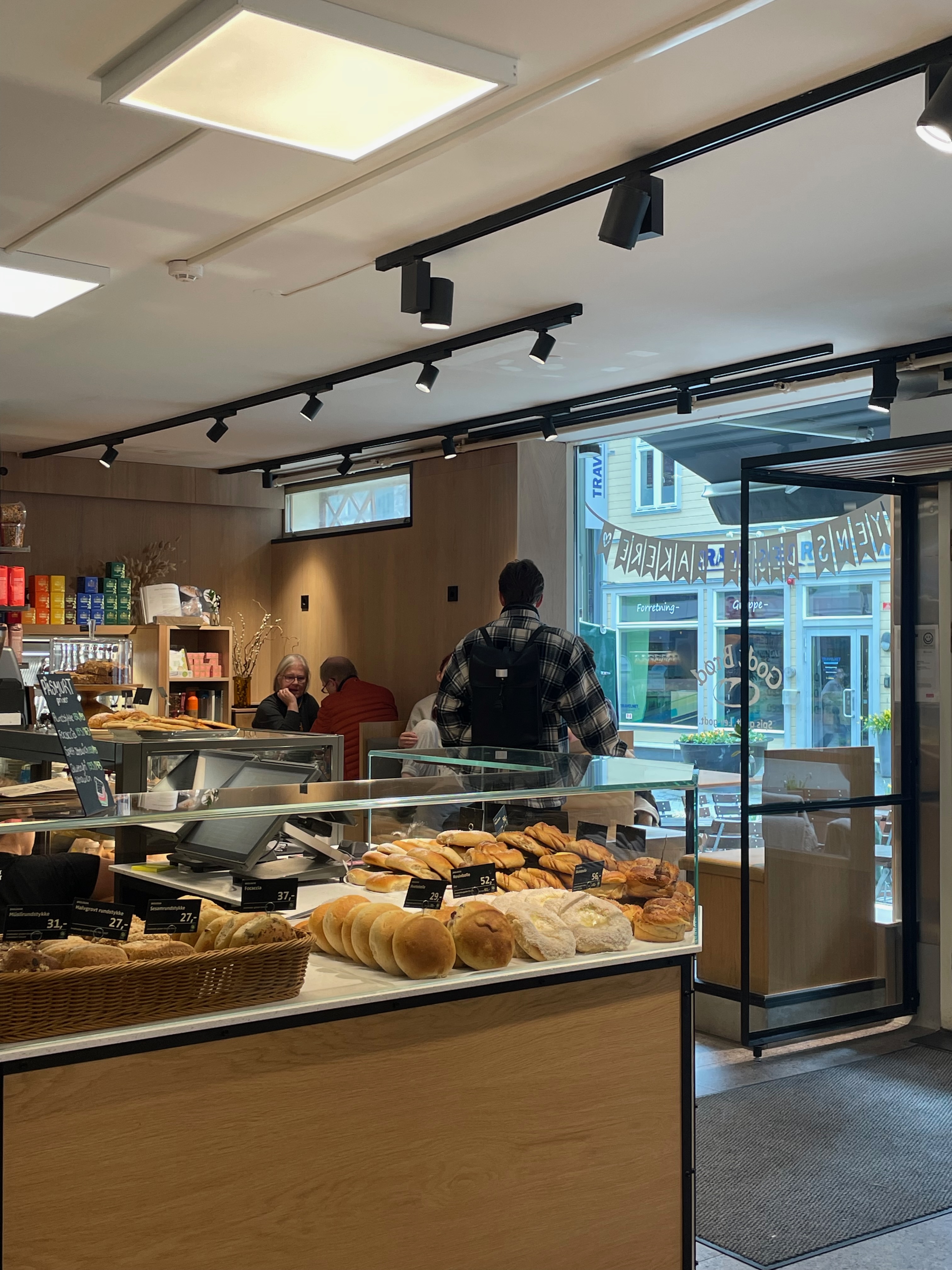 Godt Brød Trondheim counter with baked goods, indoor seating and open entrance near Thomas Angells gate