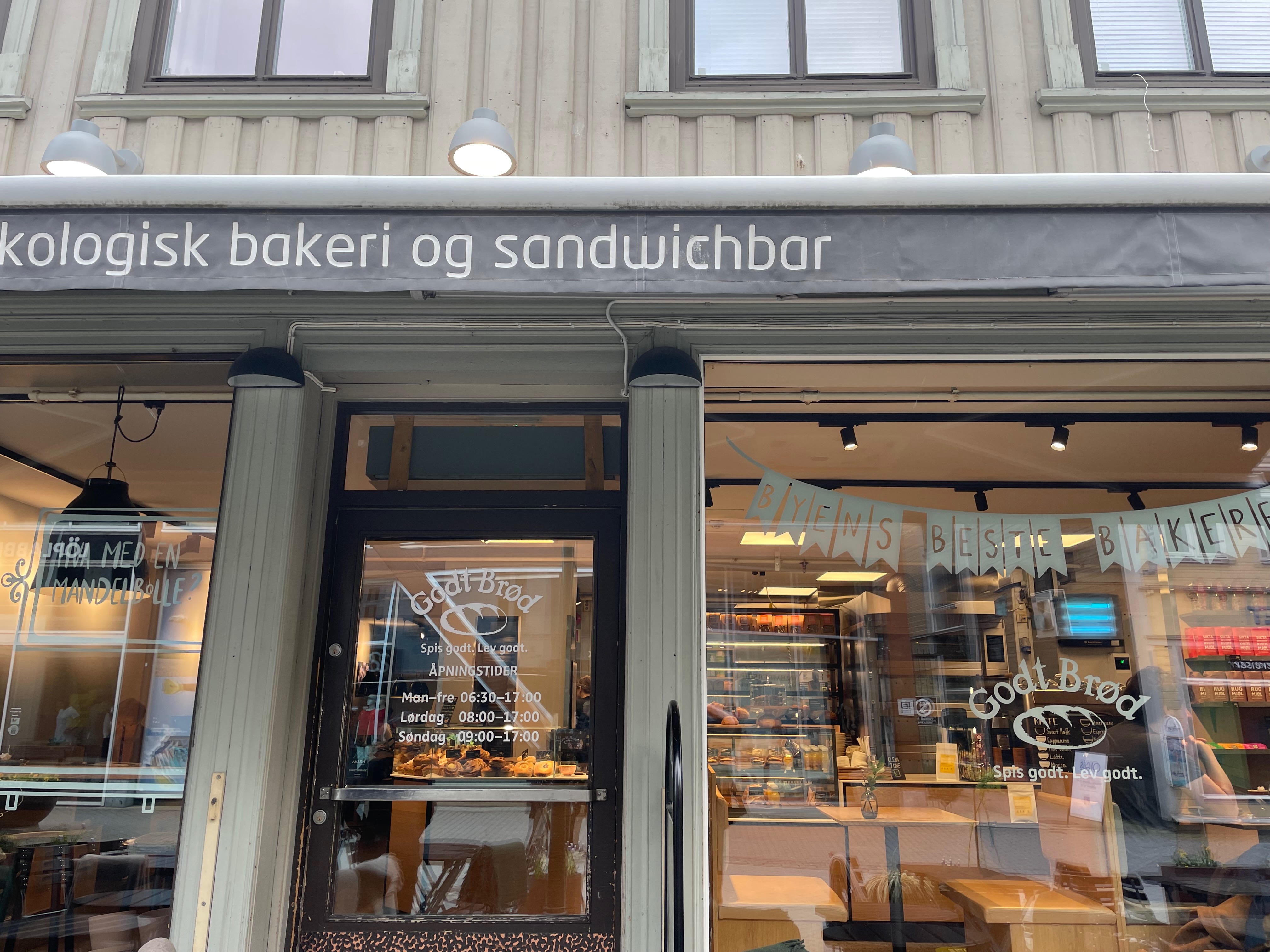 Godt Brød Trondheim storefront with organic bakery and sandwich bar sign, opening hours and cafe interior visible