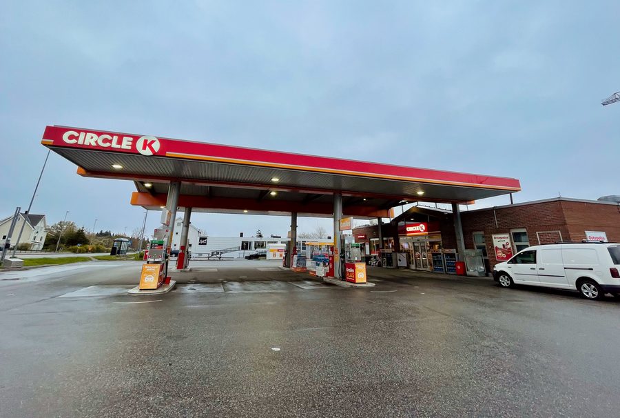 Circle K Molde gas station on a rainy day with fuel pumps, shop entrance, wet pavement, and a cloudy Norwegian sky