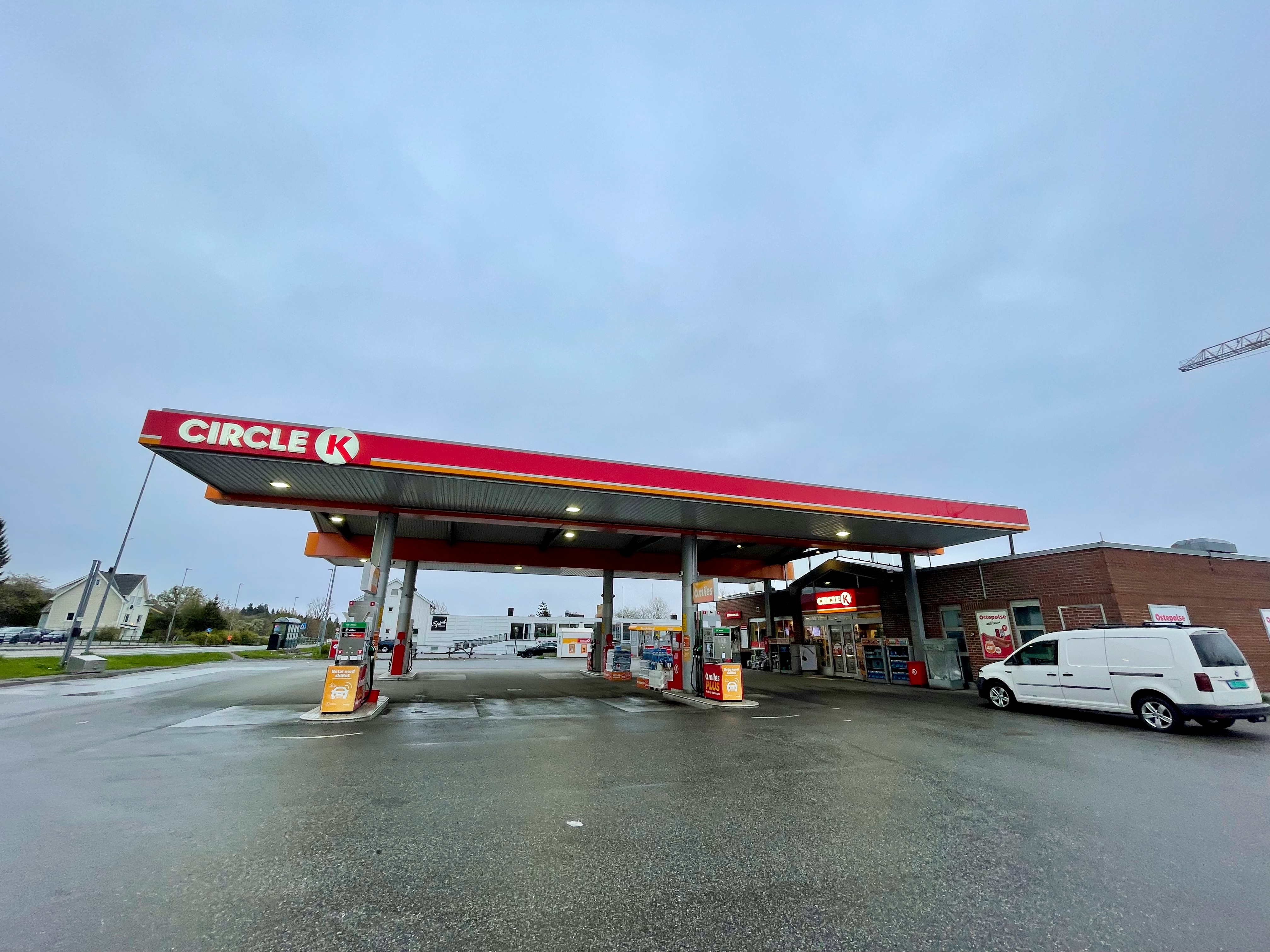 Circle K Molde forecourt with red Circle K canopy, fuel pumps, white van, and wide rainy road trip setting in Norway