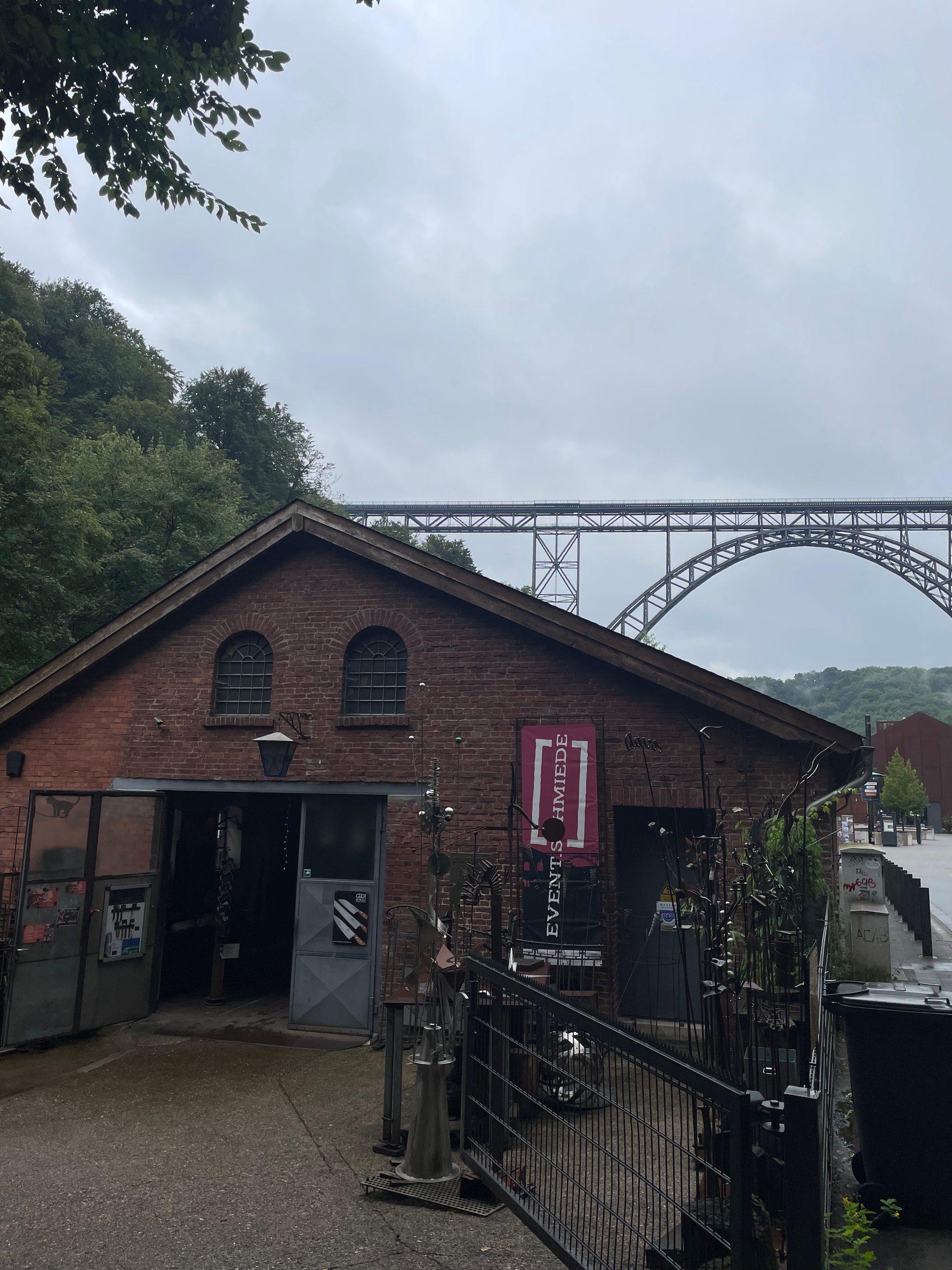 Müngstener Brücke view behind Eventschmiede Solingen, showing the historic forge building below Germany’s highest railway bridge in Solingen.