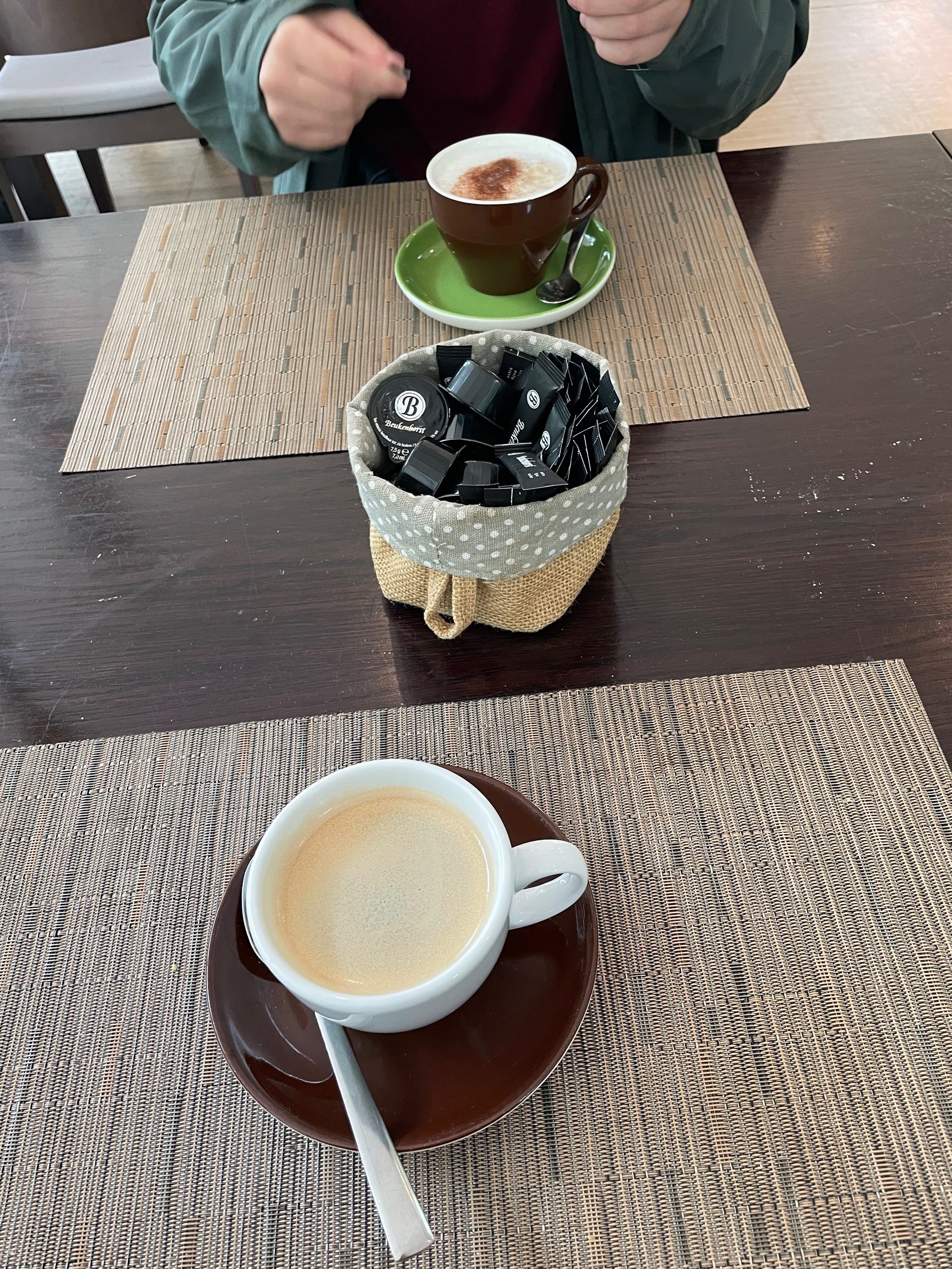 Müngstener Brücke coffee stop at Haus Müngsten, with two cups of coffee on a table, sugar packets and a quiet café setting in Solingen, Germany.