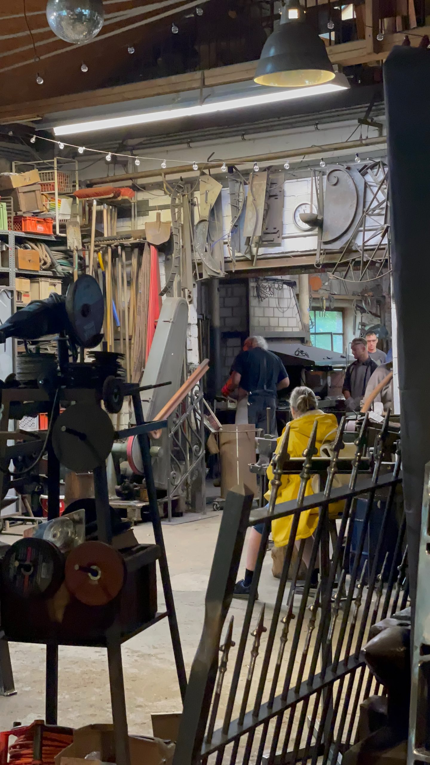 Müngstener Brücke area with blacksmith workshop activity inside Eventschmiede Solingen, where visitors watch traditional metalwork in progress.