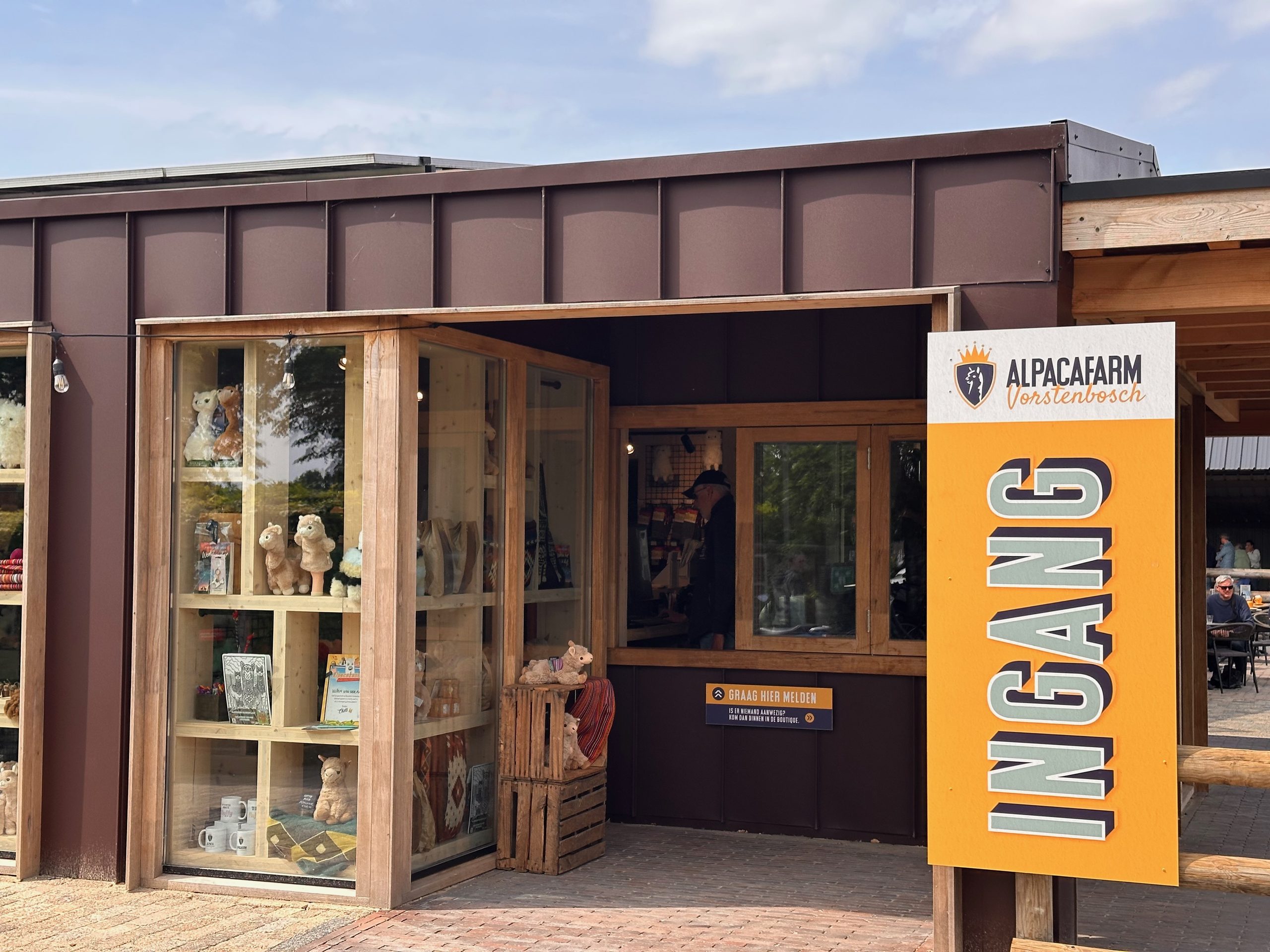 Alpacafarm Vorstenbosch review, close view of the main entrance, orange ingang sign, and alpaca themed boutique at the farm