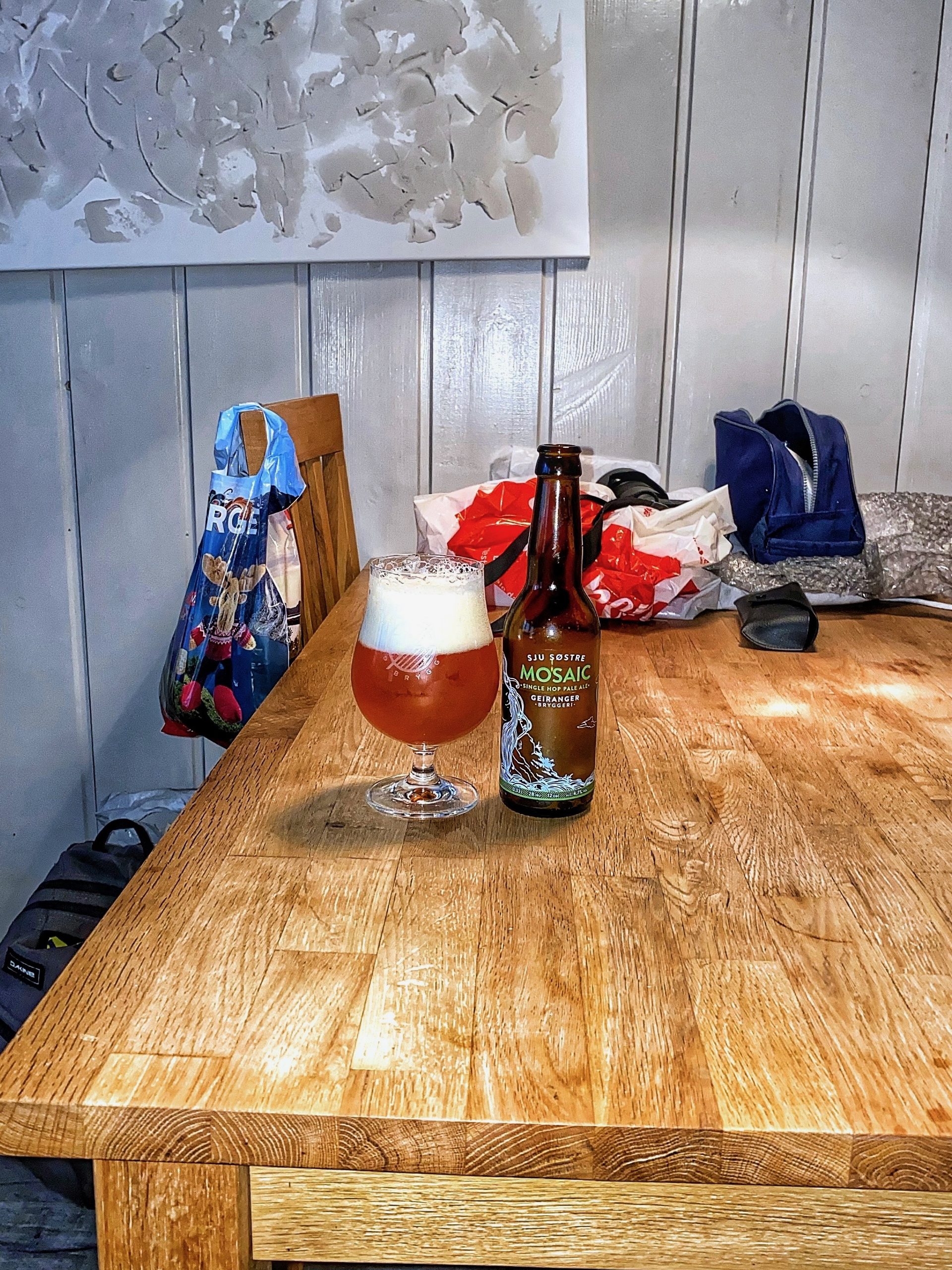 Geiranger Airbnb table with local Geiranger beer in a glass and bottle after grocery shopping for dinner