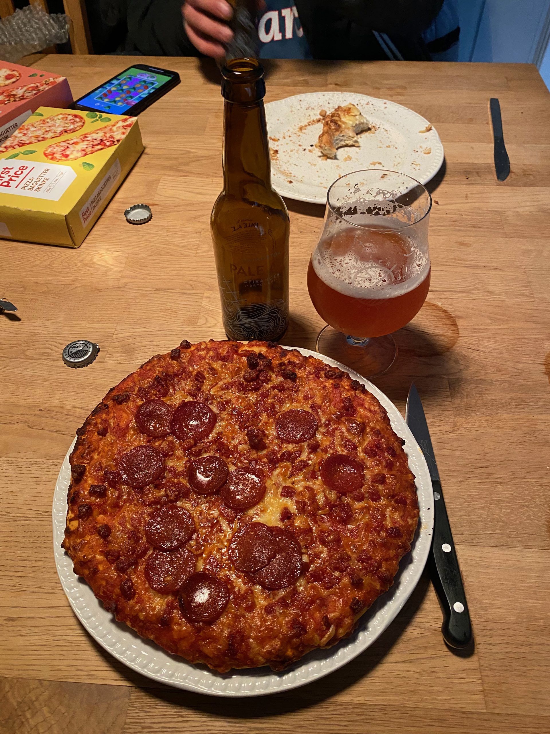 Geiranger Airbnb dinner with pepperoni pizza, local Geiranger beer, and simple roadtrip meal inside the apartment