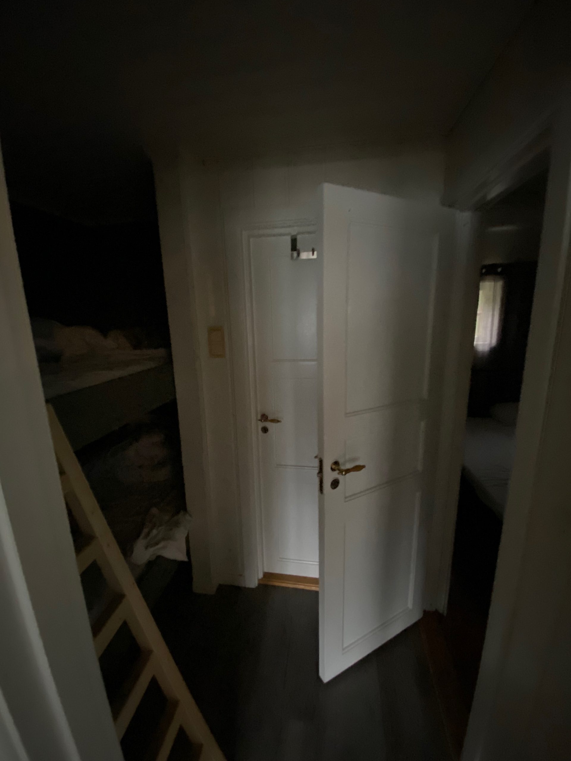 Geiranger Airbnb interior with dark hallway, bunk bed, white doors, and bedroom entrance inside the fjord view apartment